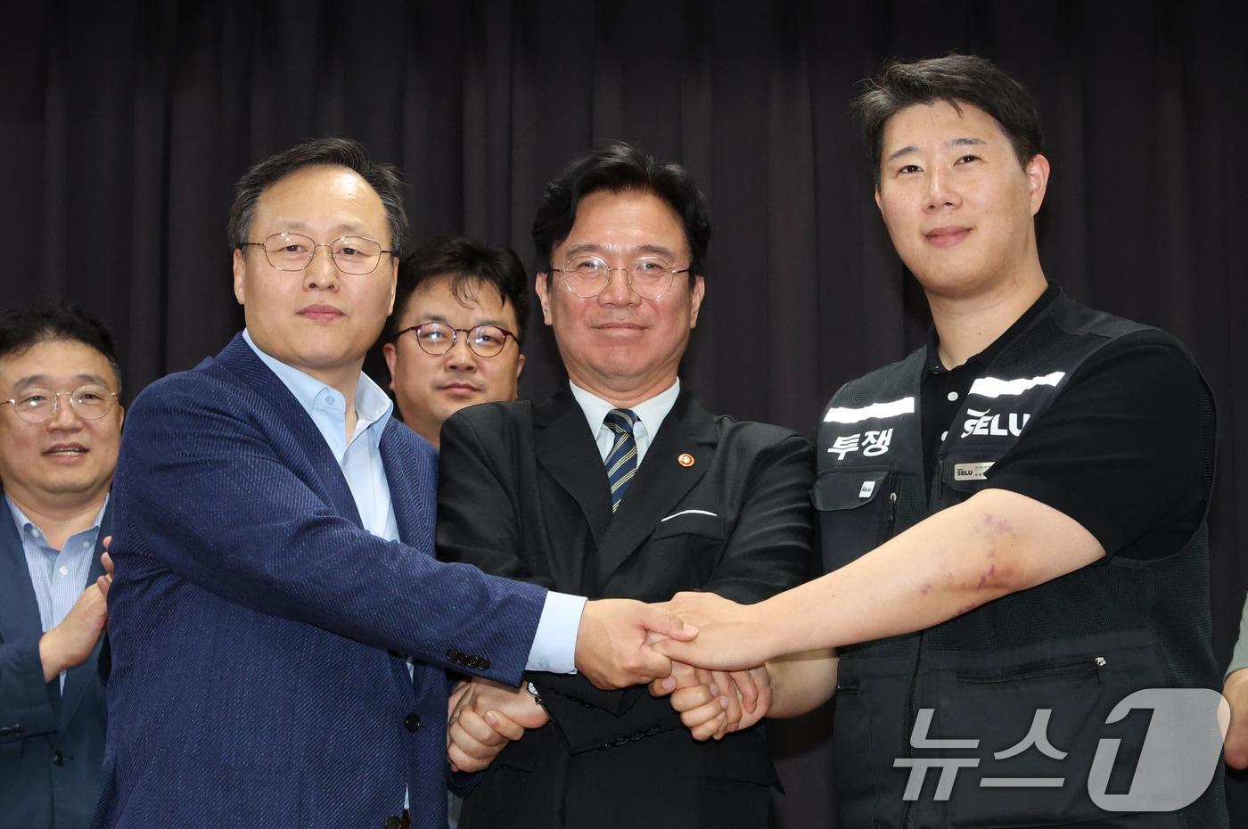 본문 이미지 - 20일 경기 수원시 장안구 경기고용노동청에서 열린 삼성전자 임금협상을 마친 후 여명구 삼성전자 DS(디바이스솔루션·반도체 사업 담당) 피플팀장(왼쪽부터)과 김영훈 고용노동부 장관, 최승호 삼성그룹 초기업노동조합 삼성전자지부 위원장이 잠정 합의한에 서명한 후 손을 맞잡고  있다. 2026.5.20 ⓒ 뉴스1 김영운 기자
