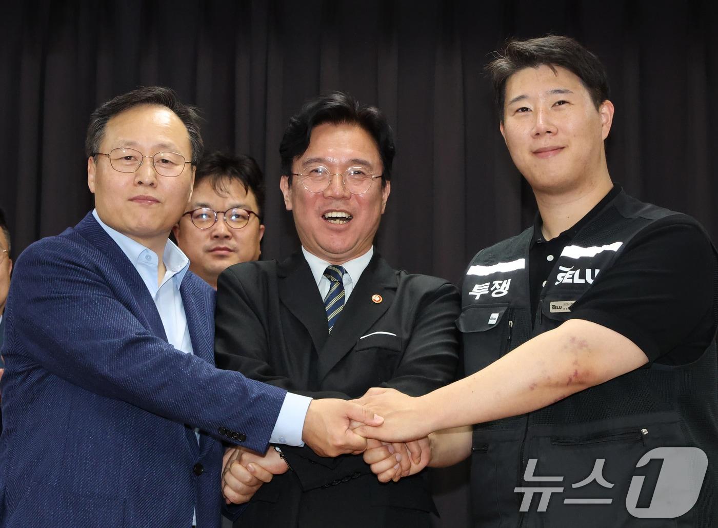 본문 이미지 - 20일 경기 수원시 장안구 경기고용노동청에서 열린 삼성전자 임금협상을 마친 후 여명구 삼성전자 DS(디바이스솔루션·반도체 사업 담당) 피플팀장(왼쪽부터)과 김영훈 고용노동부 장관, 최승호 삼성그룹 초기업노동조합 삼성전자지부 위원장이 잠정 합의한에 서명한 후 손을 맞잡고 있다. 2026.5.20 ⓒ 뉴스1 김영운 기자