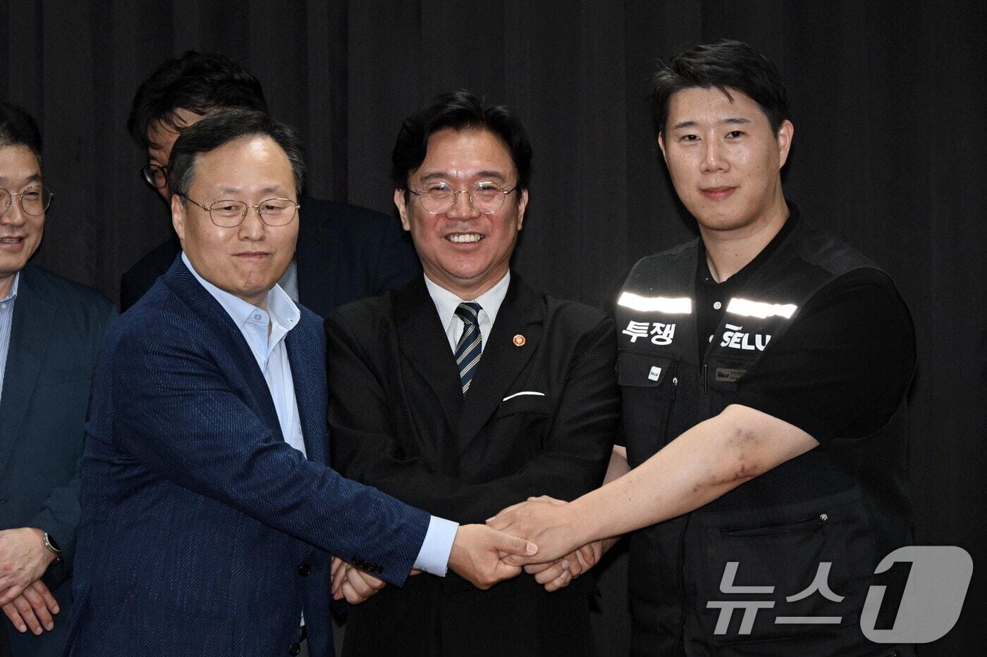 본문 이미지 - 20일 경기도 수원시 장안구 경기고용노동청에서 열린 삼성전자 임금협상을 마친 후 여명구 삼성전자 DS(디바이스솔루션·반도체 사업 담당) 피플팀장과 김영훈 고용노동부 장관, 최승호 삼성그룹 초기업노동조합 삼성전자지부 위원장이 잠정 합의한에 서명한 후 손을 맞잡고 있다. (공동취재) 2026.5.20 ⓒ 뉴스1 김영운 기자
