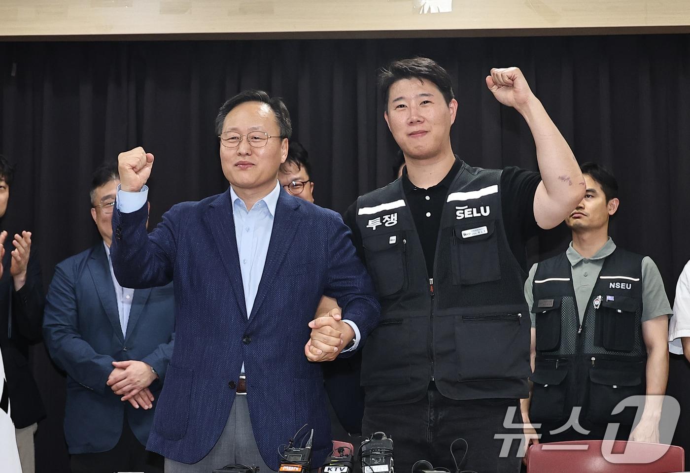 본문 이미지 - 20일 경기 수원시 장안구 경기고용노동청에서 열린 삼성전자 임금협상을 마친 후 여명구 삼성전자 DS(디바이스솔루션·반도체 사업 담당) 피플팀장과 최승호 삼성그룹 초기업노동조합 삼성전자지부 위원장이 잠정 합의안에 서명한 후 파이팅을 외치고 있다. (공동취재) 2026.5.20 ⓒ 뉴스1 김영운 기자