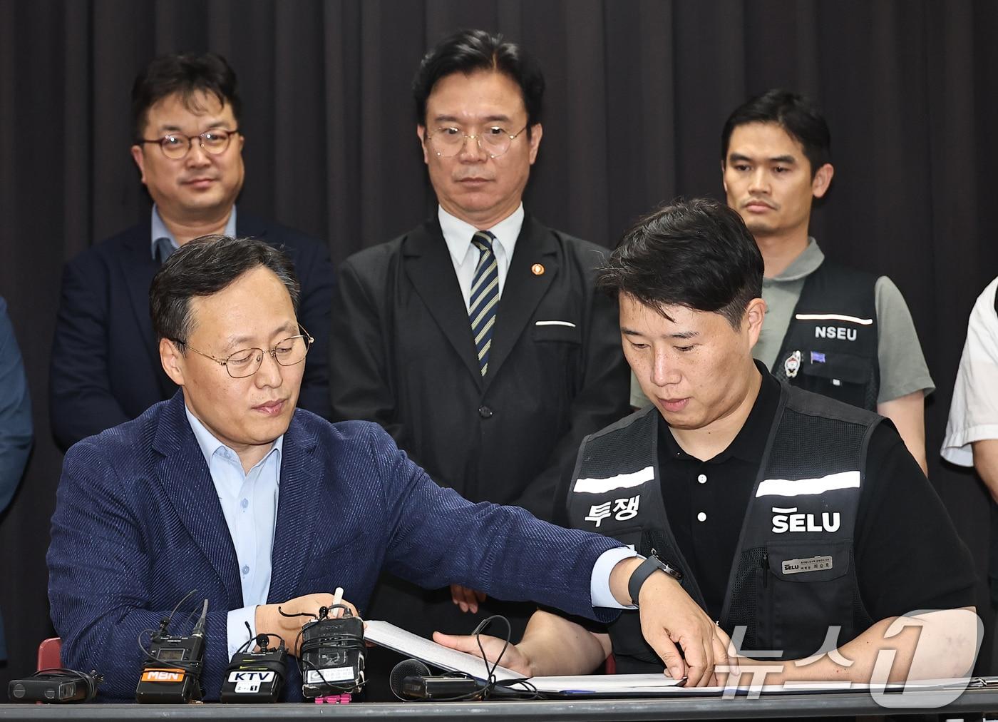 본문 이미지 - 20일 경기 수원시 장안구 경기고용노동청에서 열린 삼성전자 임금협상을 마친 후 여명구 삼성전자 DS(디바이스솔루션·반도체 사업 담당) 피플팀장과 최승호 삼성그룹 초기업노동조합 삼성전자지부 위원장이 잠정 합의안에 서명을 하고 있다. (공동취재) 2026.5.20 ⓒ 뉴스1 김영운 기자