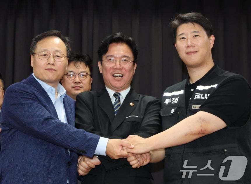 본문 이미지 - 20일 경기 수원시 장안구 경기고용노동청에서 열린 삼성전자 임금협상을 마친 후 여명구 삼성전자 DS(디바이스솔루션·반도체 사업 담당) 피플팀장(왼쪽부터)과 김영훈 고용노동부 장관, 최승호 삼성그룹 초기업노동조합 삼성전자지부 위원장이 잠정 합의한에 서명한 후 손을 맞잡고 있다. 2026.5.20 ⓒ 뉴스1 김영운 기자