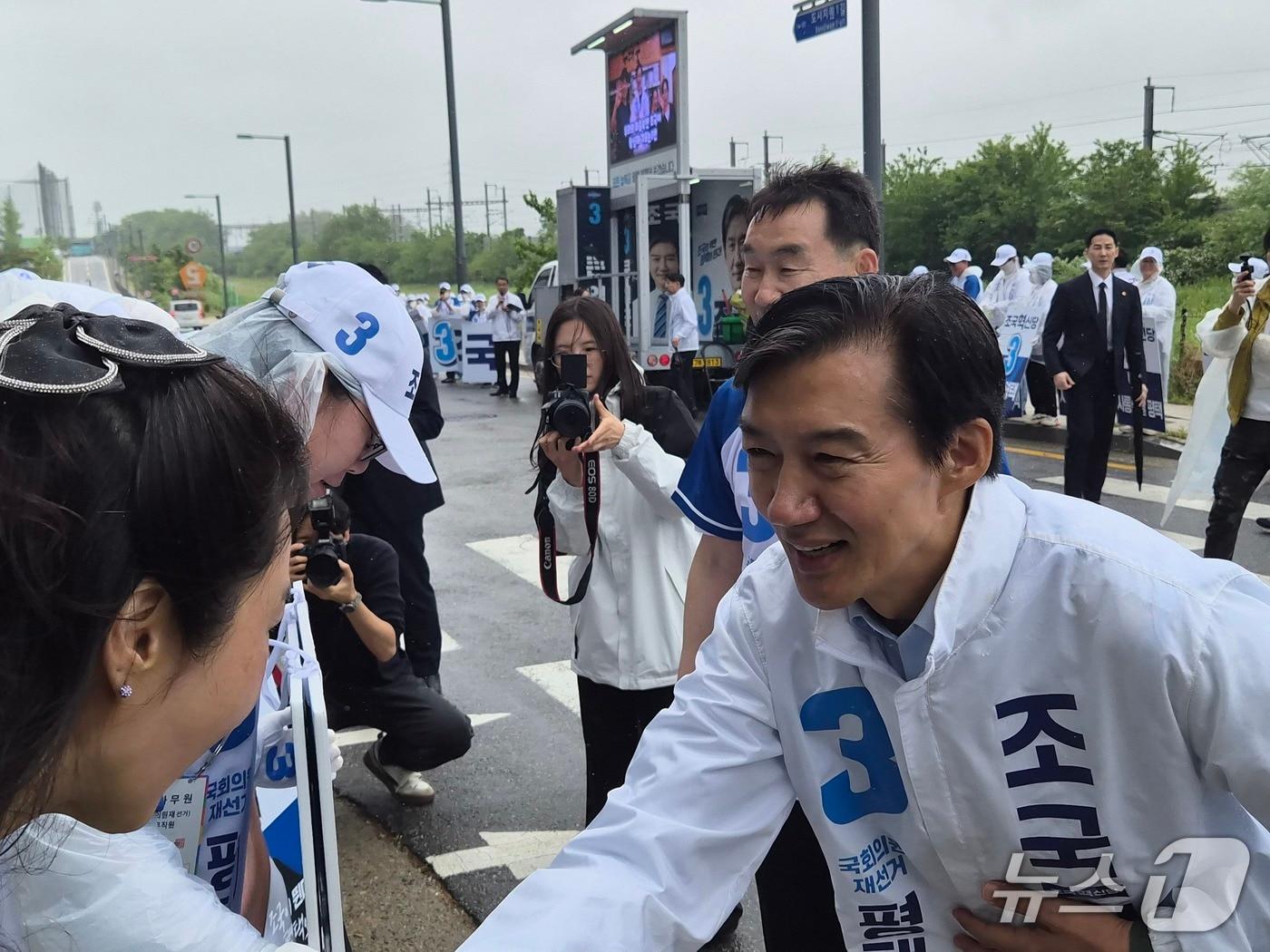 본문 이미지 - 조국 조국혁신당 경기 평택을 국회의원 재선거 후보가  21일 오전 평택시 고덕면 해창리 KTX 경기남부역 예정 부지에서 공식선거운동 출정식을 열었다. 사진은 선거운동원들과 악수를 나누고 있는 모습. 2026.5.21 ⓒ 뉴스1 김기현 기자 