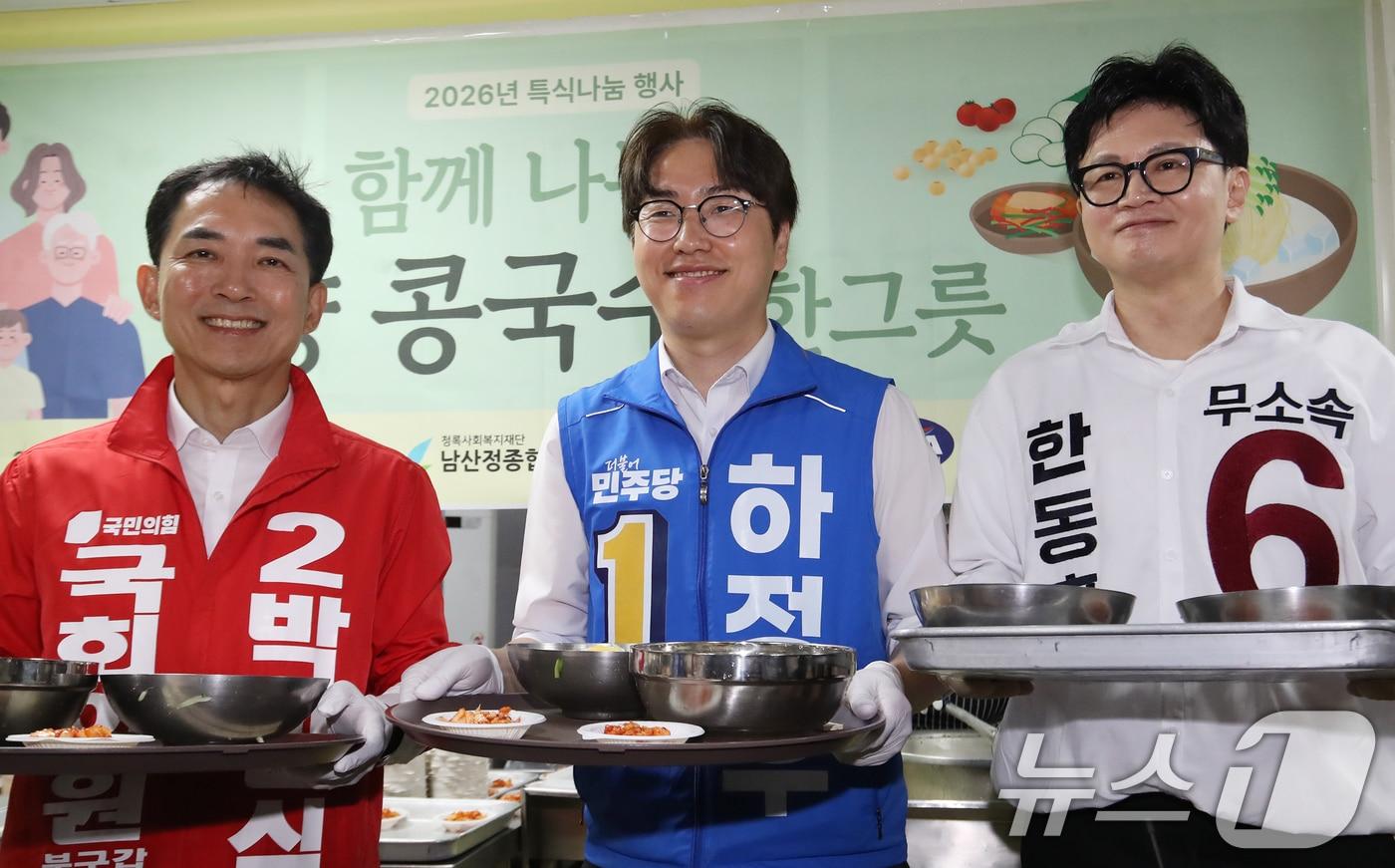 본문 이미지 - 박민식 국민의힘 부산 북구갑 국회의원 보궐선거 후보(왼쪽부터), 하정우 더불어민주당 부산 북구갑 국회의원 보궐선거 후보, 한동훈 무소속 부산 북구갑 국회의원 보궐선거 후보가 지난 21일 부산 북구 남산정종합사회복지관에서 열린 콩국수 나눔 행사에 참석해 콩국수 봉사를 하며 어르신들께 지지를 호소하고 있다. 2026.5.21 ⓒ 뉴스1 윤일지 기자