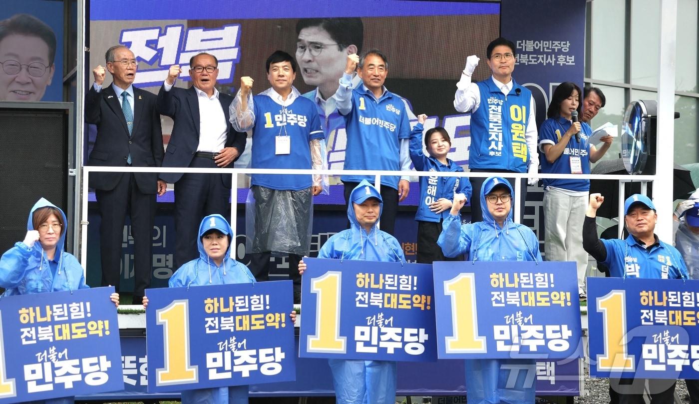 본문 이미지 - 21일 전북 전주시 전북도청사거리에서 열린 더불어민주당 전북도당 유세단 출정식에서 윤준병 민주당 전북도당위원장을 비롯한 관계자들이 시민들에게 지지를 호소하고 있다. 2026.5.21 ⓒ 뉴스1 유경석 기자