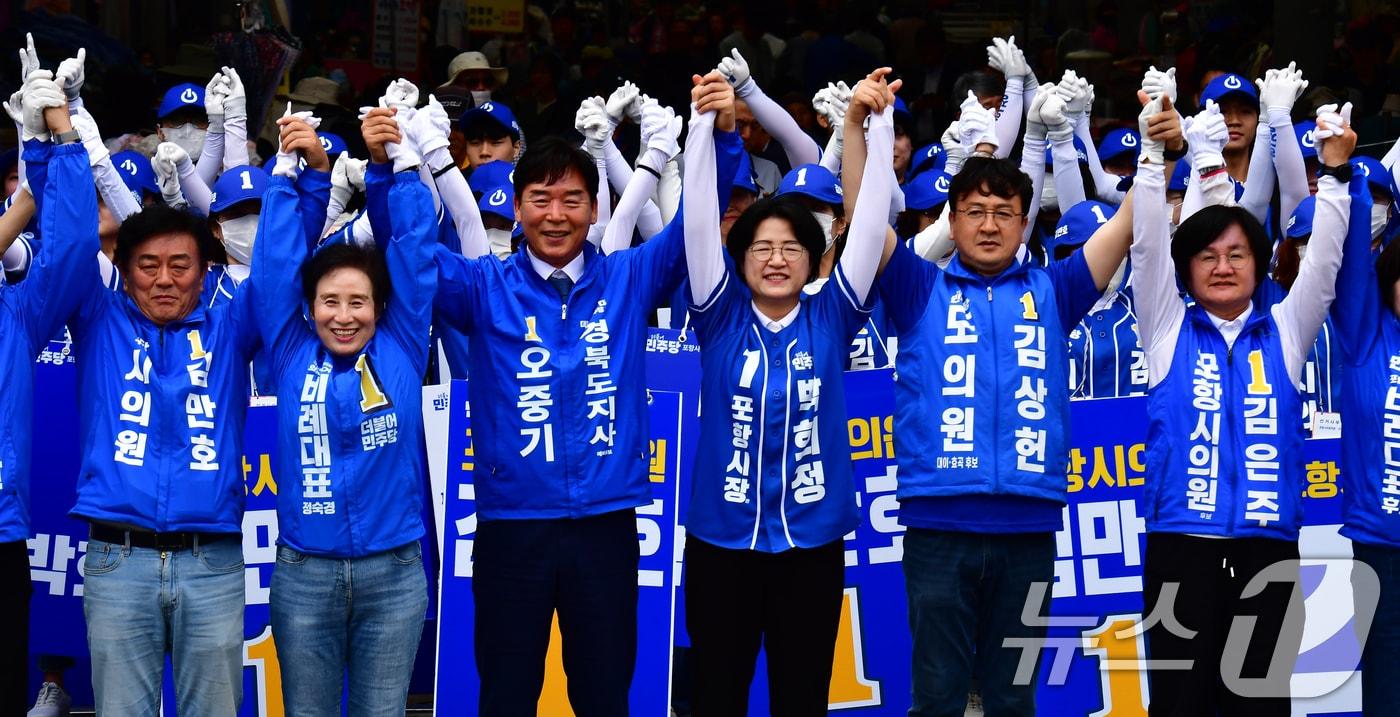 본문 이미지 - 오중기 더불어민주당 경북도지사 후보와 박희정 포항시장 후보, 시·도의원 후보들이 21일 오후 포항 죽도시장 입구에서 열린 공동 출정식에서 승리를 다짐하고 있다. 2026.5.21 ⓒ 뉴스1 최창호 기자