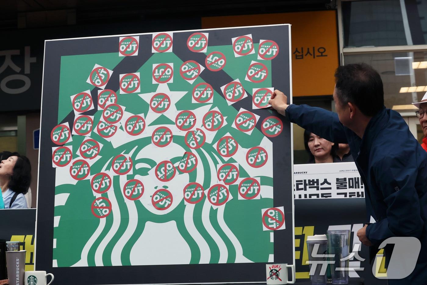 본문 이미지 - 오월을 사랑하는 모임 등 광주시민단체 들이 21일 오후 광주 서구 광천동 이마트 광주점 앞에서 스타벅스의 '5·18 탱크데이' 마케팅을 규탄하는 기자회견을 열고 스타벅스 OUT 스티커를 붙이고 있다. 2026.5.21 ⓒ 뉴스1 조수민 수습기자