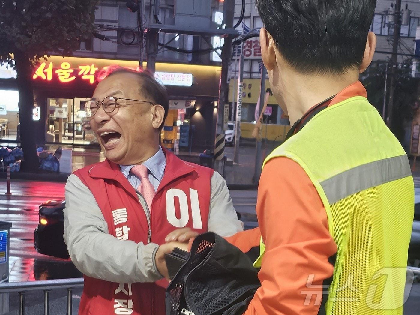 본문 이미지 - 이정현 국민의힘 전남광주특별시장 후보가 첫 공식 선거운동일인 지난 21일 광주 북구청 앞에서 환경미화원을 만나 활짝 웃고 있다.(국민의힘 제공. 재배포 및 DB 금지) 2026.5.21 ⓒ 뉴스1