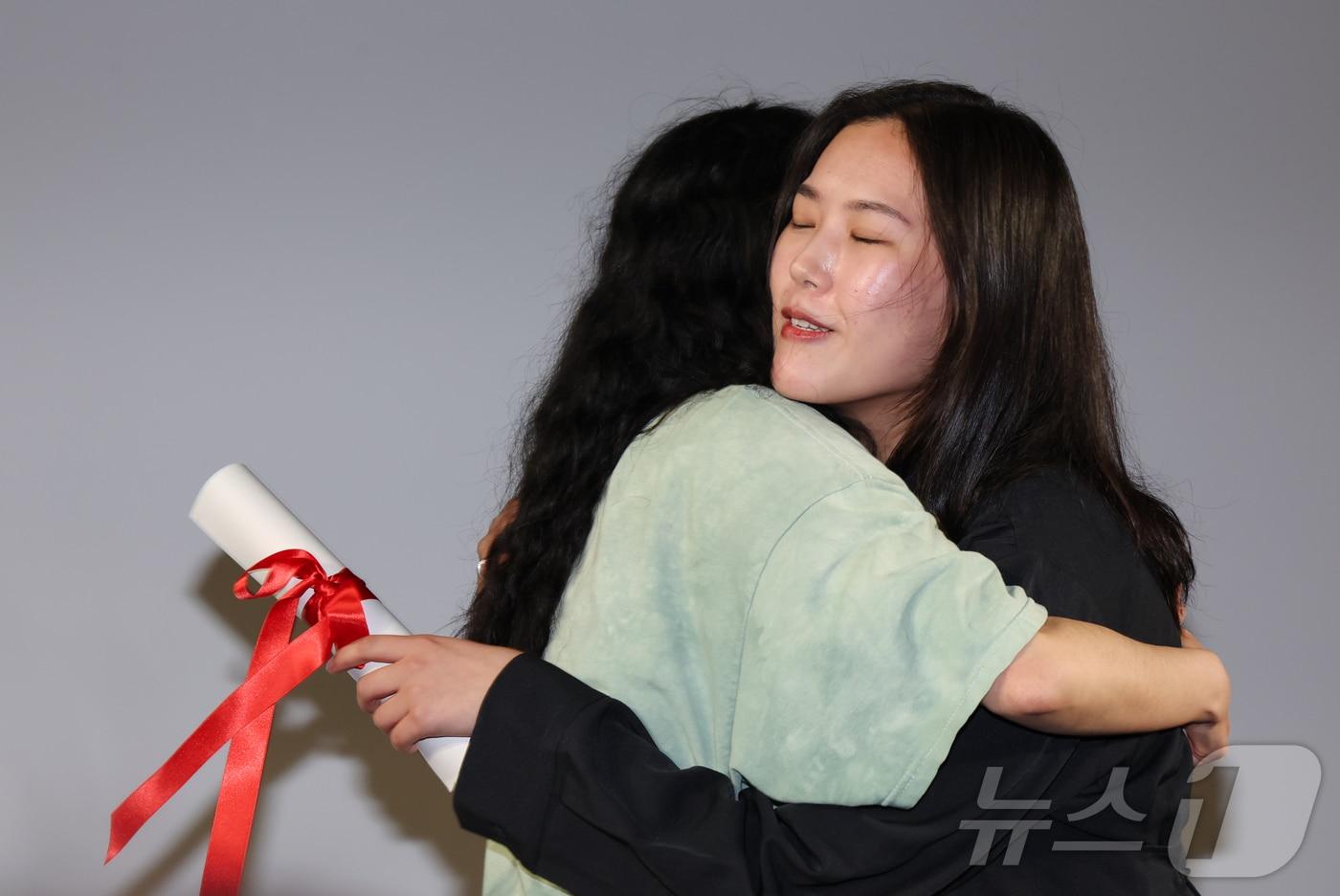 본문 이미지 - 제79회 칸 국제영화제 학생 영화 부문인 라 시네프 섹션 진출작 ‘사일런트 보이시스’의 나딘 미송 진 감독이 21일(현지시간) 프랑스 남부 소도시 칸 팔레 데 페스티발 부뉴엘관에서 열린 라 시네프 시상식에서 2등상을 받은 뒤 시상자로 나선 한국계 프랑스 배우 박지민 심사위원과 포옹하고 있다. 2026.5.22 ⓒ 뉴스1 이준성 특파원