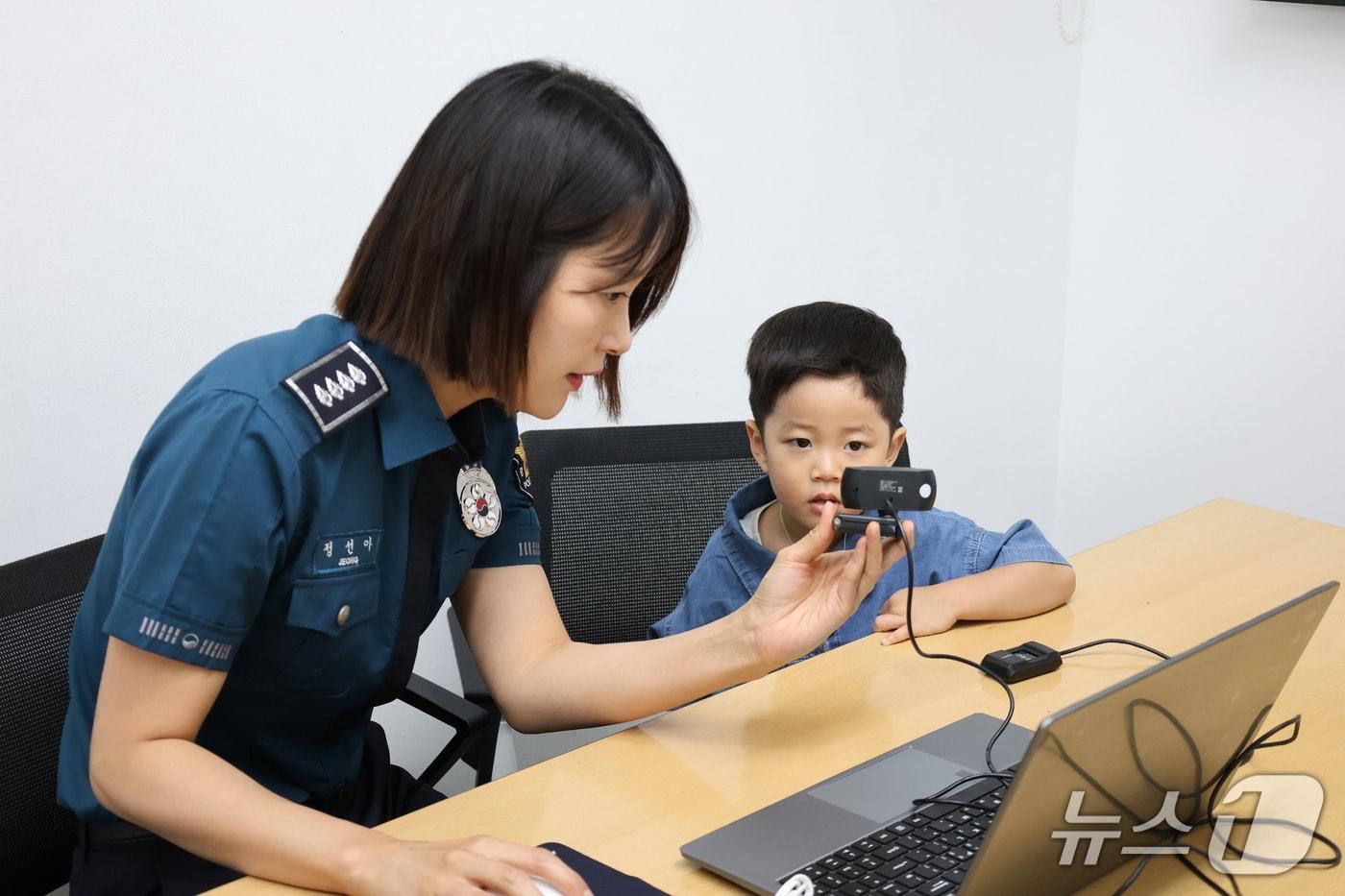 본문 이미지 - 전북경찰청 소속 경찰관이 아동과 함께 지문을 등록하고 있다. 경찰은 지난 2012년 7월부터 '실종예방 사전등록' 제도를 시행하고 있으며, 전북에서는 지난 4월까지 전체 18세 미만 아동 중 73.1%가 실종예방을 위해 사전등록을 한 것으로 파악됐다.(전북경찰청 제공. 재판매 및 DB 금지)