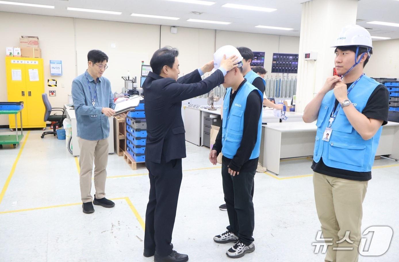 본문 이미지 - 한국조폐공사 김범진 상임감사가 지난 20일 대전광역시 유성구 소재 ID본부 여권발급부에서 직원에게 안전모를 수여하고 있다.(한국조폐공사 제공.재판매 및 DB금지)/뉴스1