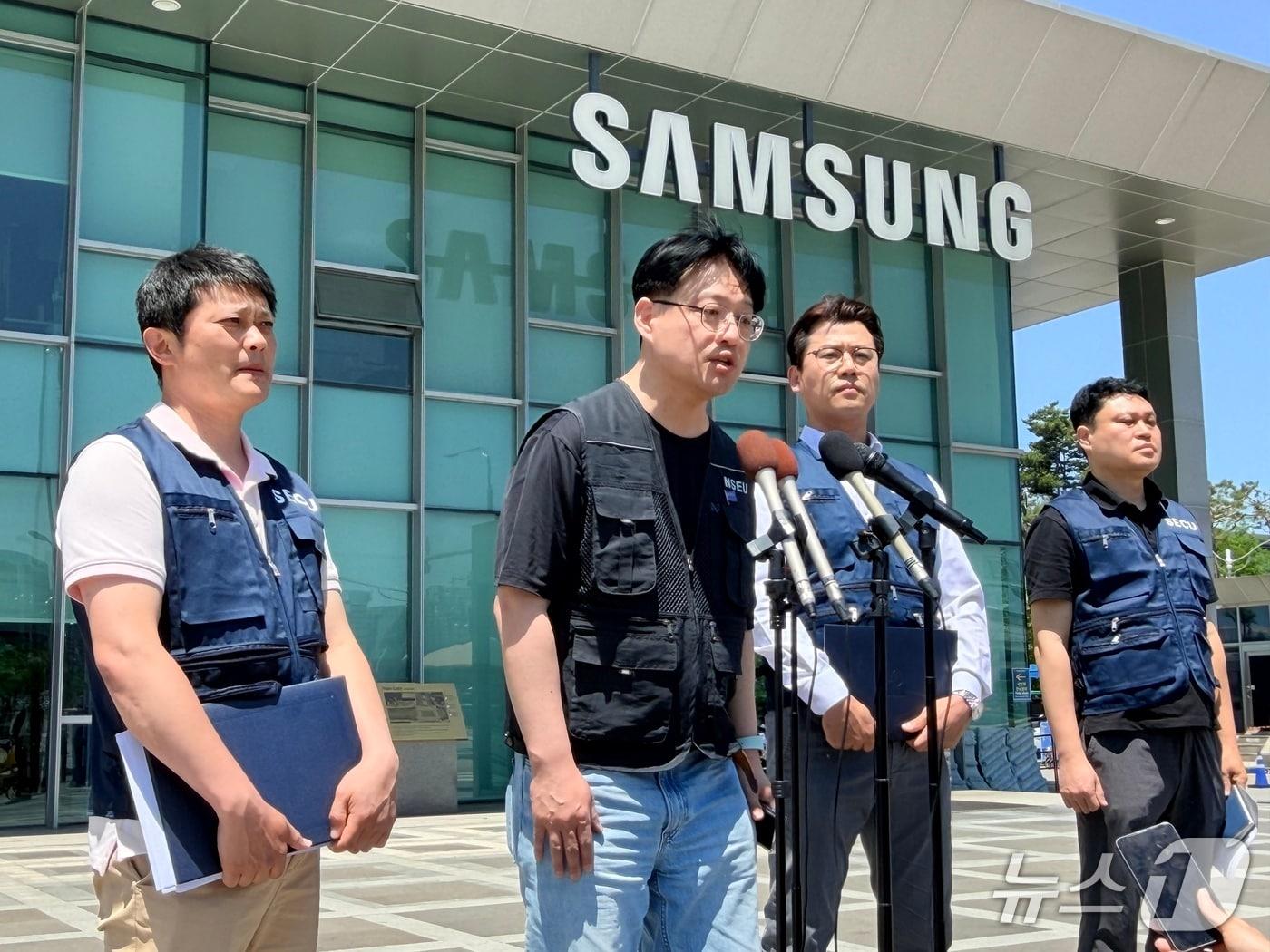 본문 이미지 - 전국삼성전자노동조합(NSEU) 수원지부와 동행노조 간부들이 22일 오후 삼성전자 수원캠퍼스 정문 앞에서 삼성전자 노자 잠정합의안 관련 긴급 기자회견을 열고 있다. ⓒ 뉴스1 최대호 기자