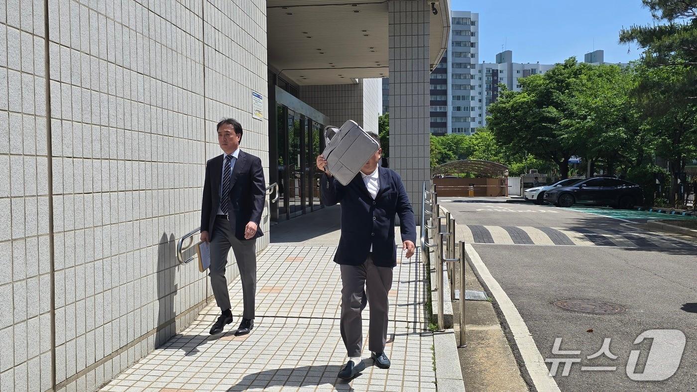 본문 이미지 - 코스닥 상장사 알에프세미 현직 대표 A 씨가 22일 오후 2시 서울남부지법 영장실질심사에 출석하며 얼굴을 가리고 있다./뉴스1 ⓒ News1 윤주영 기자