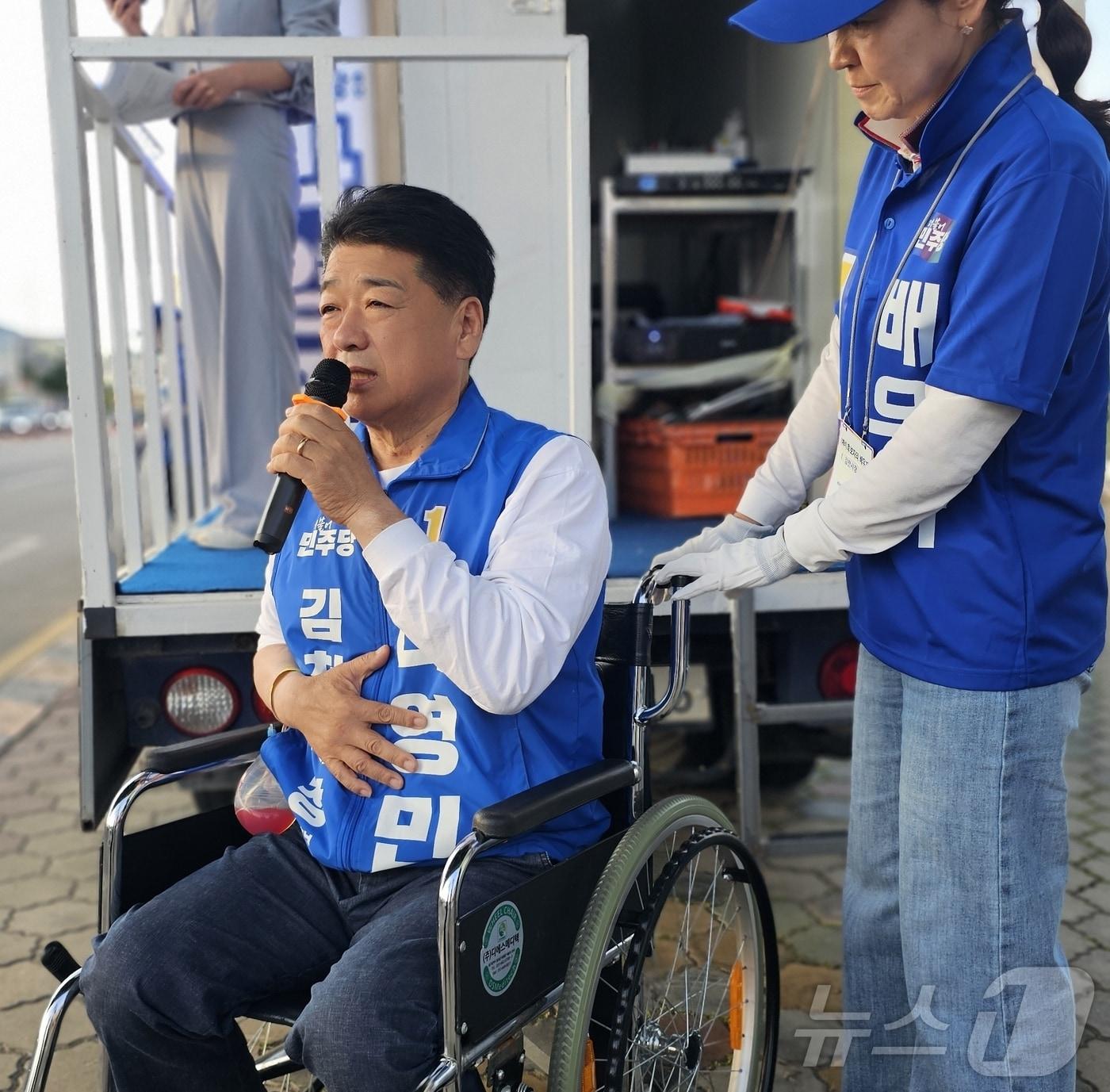 본문 이미지 - 나영민 민주당 김천시장 후보가 22일 맥도날드 사거리에서 열린 합동유세에서 부인 이경선씨의 도움을 받아 휠체어를 탄 채 선거유세를 하고 있다. (민주당 제공. 재판매 및 DB금지) ⓒ 뉴스1 정우용 기자