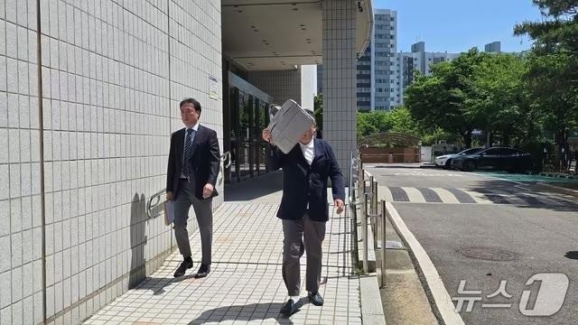 본문 이미지 - 코스닥 상장사 알에프세미 현직 대표 A 씨가 22일 오후 2시 서울남부지법 영장실질심사에 출석하며 얼굴을 가리고 있다./뉴스1 ⓒ News1 윤주영 기자