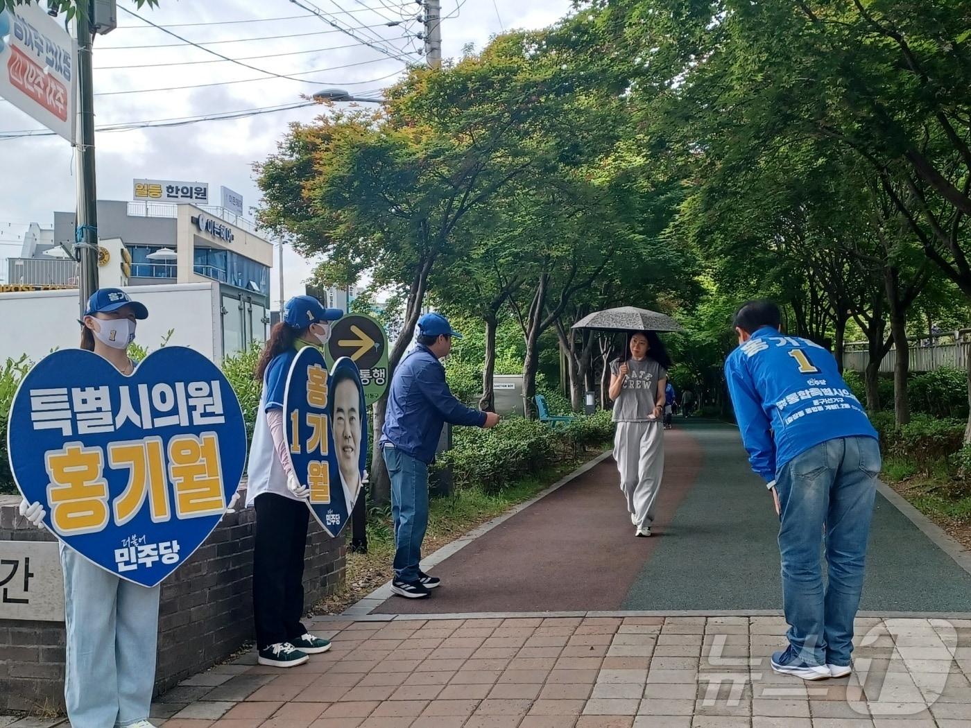 본문 이미지 - 홍기월 더불어민주당 전남광주통합특별시의원 후보가 23일 오전 광주 동구 두산위브 푸른길삼거리에서 시민들과 만나 지지를 호소하고 있다.2026.5.23 ⓒ 뉴스1 박영래 기자