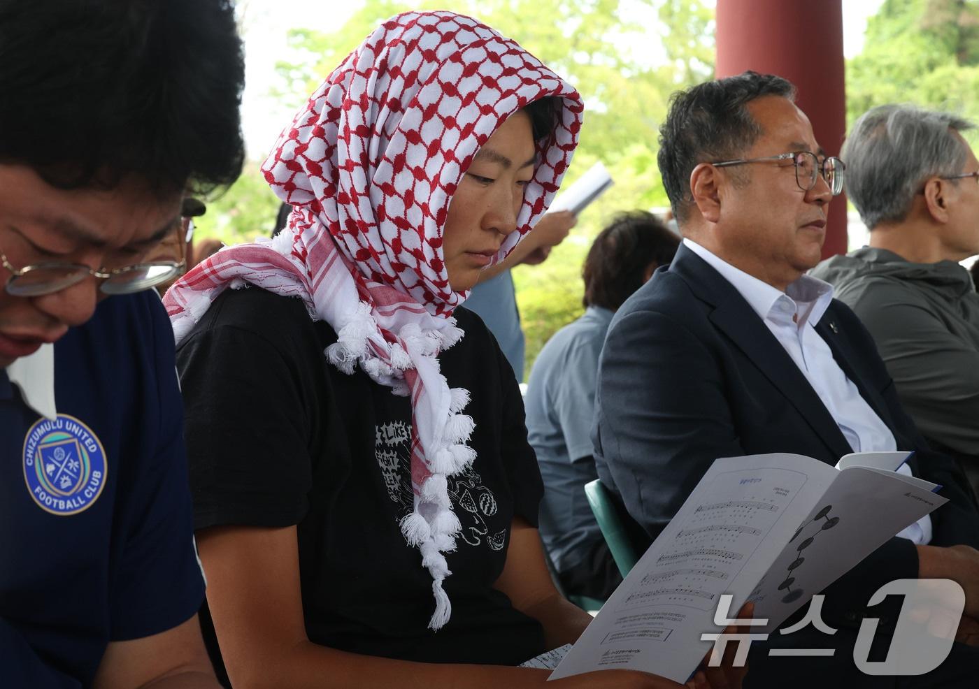 본문 이미지 - 5월23일 오전 광주 북구 운정동에 위치한 국립 5·18민주묘지 역사의문 앞에서 열린 제21회 들불상 시상식에 앞서 김아현 씨(활동명 해초)가 자료집을 살펴보고 있다. 김 활동가는 최근 팔레스타인 가자지구로 향하던 선박에 탑승했다가 이스라엘군에 억류됐다 귀국했다. 2026.5.23 ⓒ 뉴스1 박지현 기자