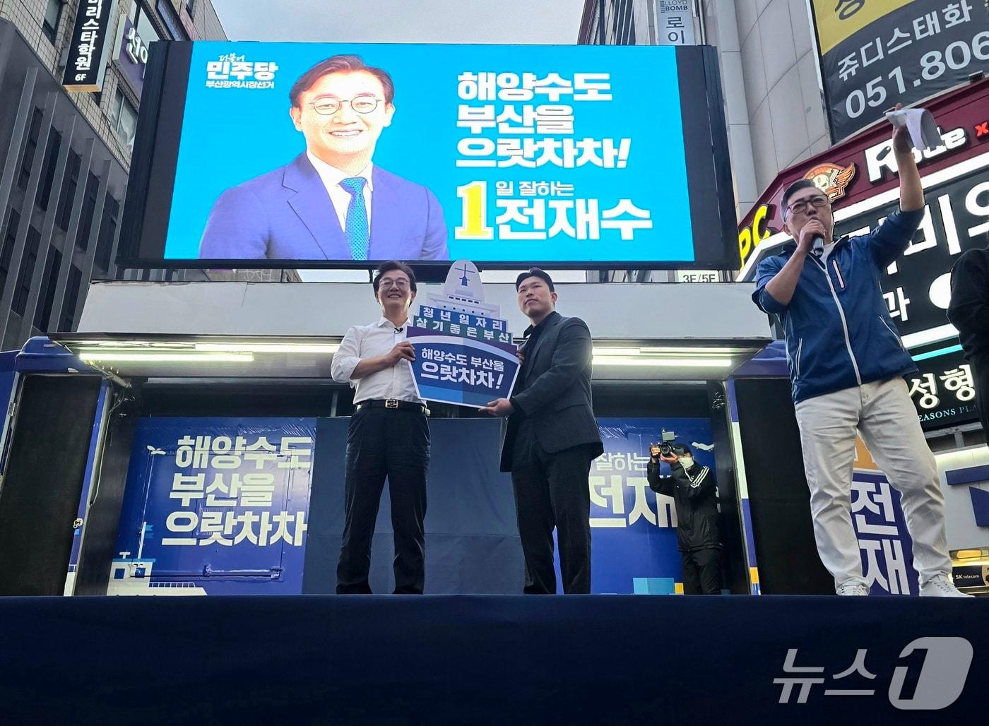 본문 이미지 - 전재수 더불어민주당 부산시장 후보가 23일 부산 부산진구 서면에서 진행된 유세 현장에서 한 청년으로부터 해양수도 비전을 담은 피켓을 받고 있다.2026.5.23 ⓒ 뉴스1 이주현 기자