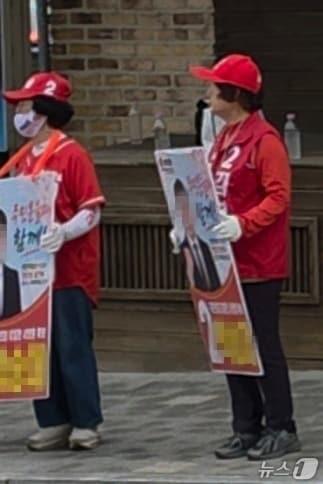 본문 이미지 -  김영환 국민의힘 충북지사 후보 재킷을 입은 선거운동원이 같은당 충주시의원 선거 후보자 피켓을 들고 선거운동하는 모습(독자 제공. 재판매 및 DB금지)