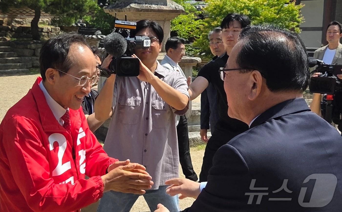본문 이미지 - 부처님오신날인 24일 김부겸 더불어민주당 대구시장 후보(오른쪽)와 추경호 국민의힘 대구시장 후보가 대구 대표 사찰인 동화사에서 열린 봉축법요식에 참석하기에 앞서 마주쳐 인사를 나누고 있다. 2026.5.24 ⓒ 뉴스1 이성덕 기자