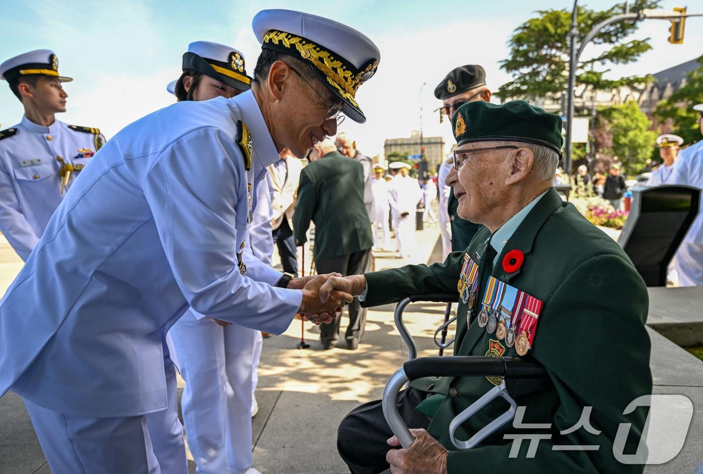 본문 이미지 - 김경률 해군참모총장이 25일(한국시간) 6·25전쟁 캐나다 참전용사를 추모하기 위해 캐나다 빅토리아 참전용사 기념비를 찾아 행사 시작 전 캐나다 참전용사 빅터 플렛 씨와 악수를 나누고 있다. (해군 제공. 재판매 및 DB 금지) 2026.5.25 ⓒ 뉴스1