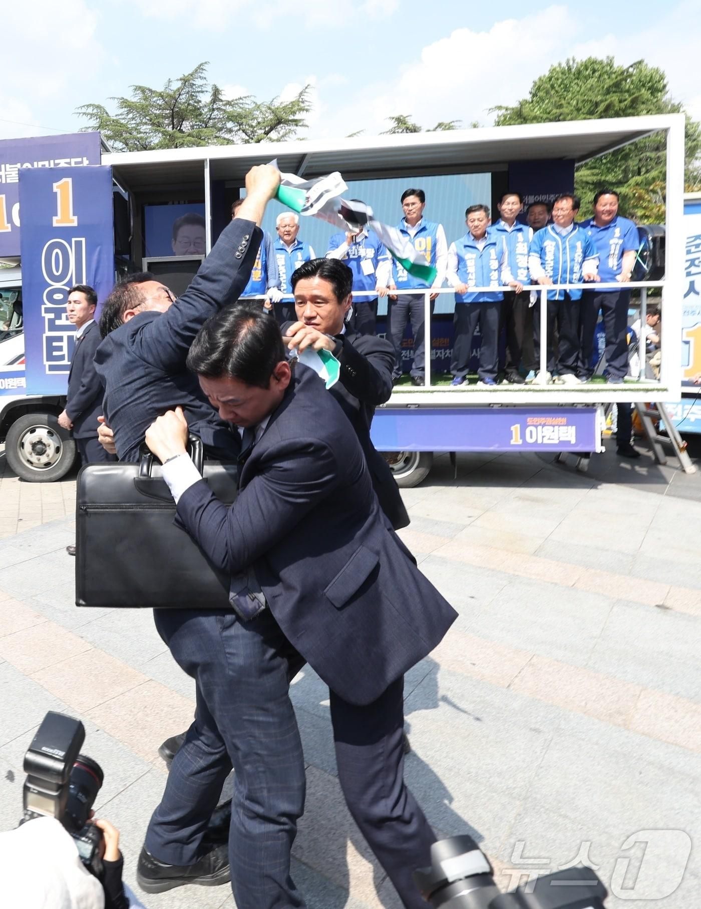 본문 이미지 - 정청래 더불어민주당 총괄상임선대위원장이 25일 전북 전주시 전북대학교 구정문 앞에서 열린 집중유세에 참석해 민주당 후보 지지를 호소하던 중 한 남성이 "정청래 아웃＂이라고 외치며 뛰어들자 경호원들이 제지하고 있다. 2026.5.25 ⓒ 뉴스1 유경석 기자