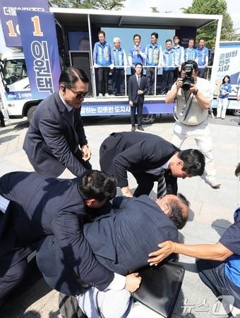 본문 이미지 - 정청래 더불어민주당 총괄상임선대위원장이 25일 전북 전주시 전북대학교 구정문 앞에서 열린 집중유세에 참석해 민주당 후보 지지를 호소하던 중 한 남성이 "정청래 아웃"이라고 외치며 뛰어들자 경호원들이 제지하고 있다. 2026.5.25 ⓒ 뉴스1 유경석 기자