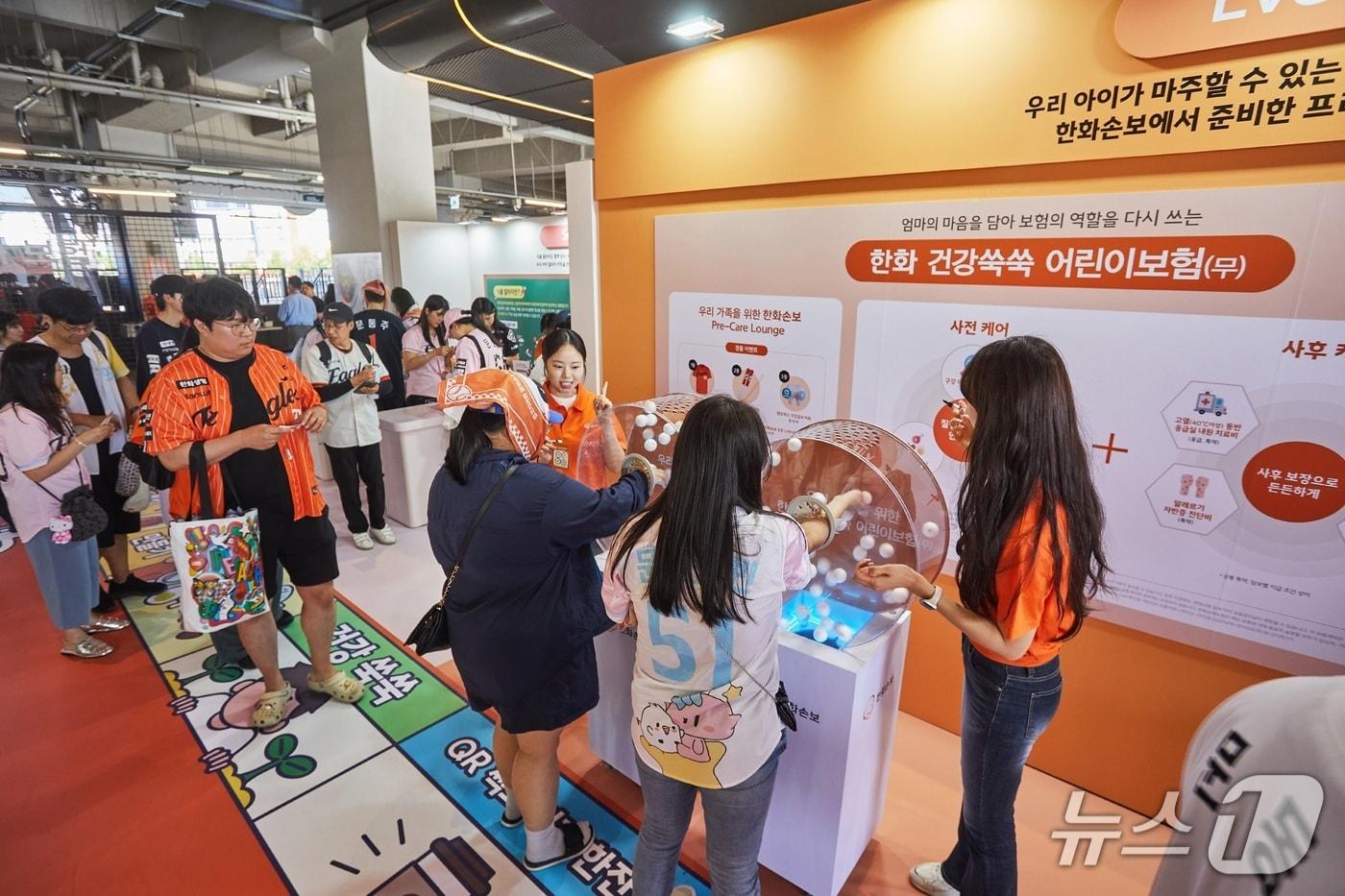 본문 이미지 - 지난 22일(금)부터 24일(일)까지 대전 한화생명볼파크에서 열린 ‘2026 한화손보 스폰서데이’에서 ‘한화손보 프리케어 라운지’에 방문한 고객들이 이벤트에 참여하고 있다./사진제공=한화손해보험