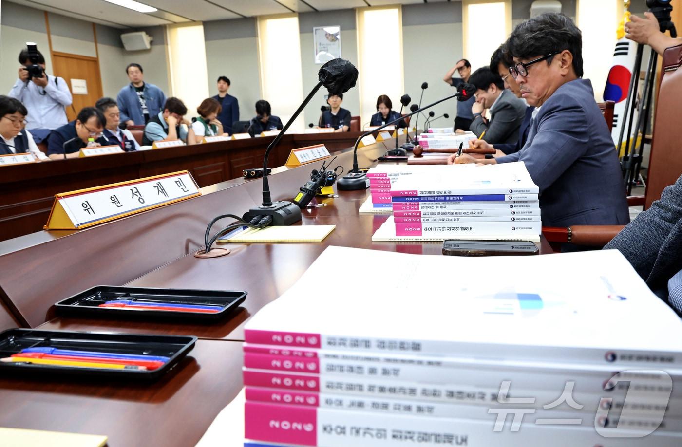 본문 이미지 - 권순원 최저임금위원회 위원장이 지난 26일 세종시 정부세종청사 최저임금위원회에서 열린 2027년도 최저임금위원회 2차 전원회의에 참석, 책상에 쌓인 최저임금 지침 자료들을 살펴보며 회의에 임하고 있다. 2026.5.26 ⓒ 뉴스1 김기남 기자