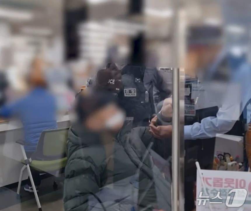 본문 이미지 - 행정복지센터 내 경찰관이 출동해 A씨를 제지하는 장면.(부산경찰청 제공. 재판매 및 DB금지).