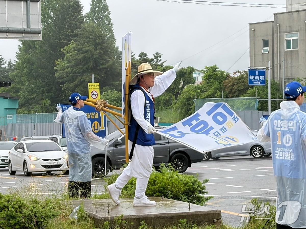 본문 이미지 - 옥천군의원에 출마한 더불어민주당 안효익 후보가  도로변에서 지게를 짊어지고 밀짚모자를 쓴 채 거리 유세를 하고 있다. (후보선거사무소 제공. 재판매 및 DB금지) /뉴스1