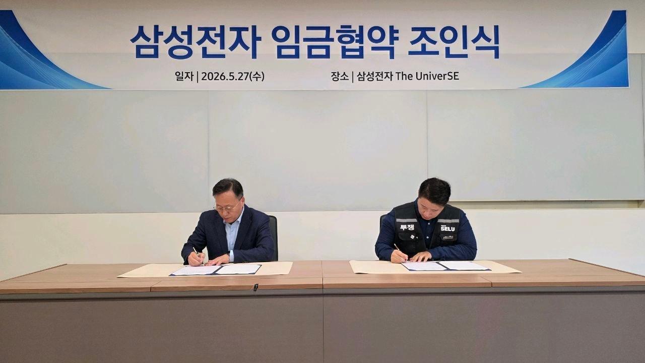 본문 이미지 - 삼성전자 사측 여명구 DS부문 피플팀장(부사장, 왼쪽)과 최승호 삼성그룹 초기업 노동조합 삼성전자지부 위원장이 조인식에서 합의안에 서명을 하고 있다.(삼성전자 제공)/뉴스1