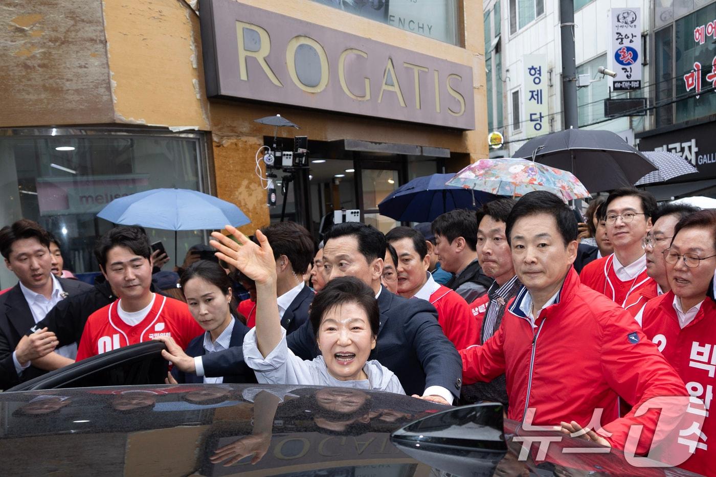 본문 이미지 - 박근혜 전 대통령이 27일 오전 11시 무렵 경남 진주 대안동 진주중앙시장을 찾아 박완수 국민의힘 경남도지사 후보, 한경호 진주시장 후보 등 국민의힘 후보자 지원유세를 한 뒤 시민들에게 인사하고 있다. 오른쪽은 유영하 의원. (공동취재) 2026.5.27 ⓒ 뉴스1 윤일지 기자