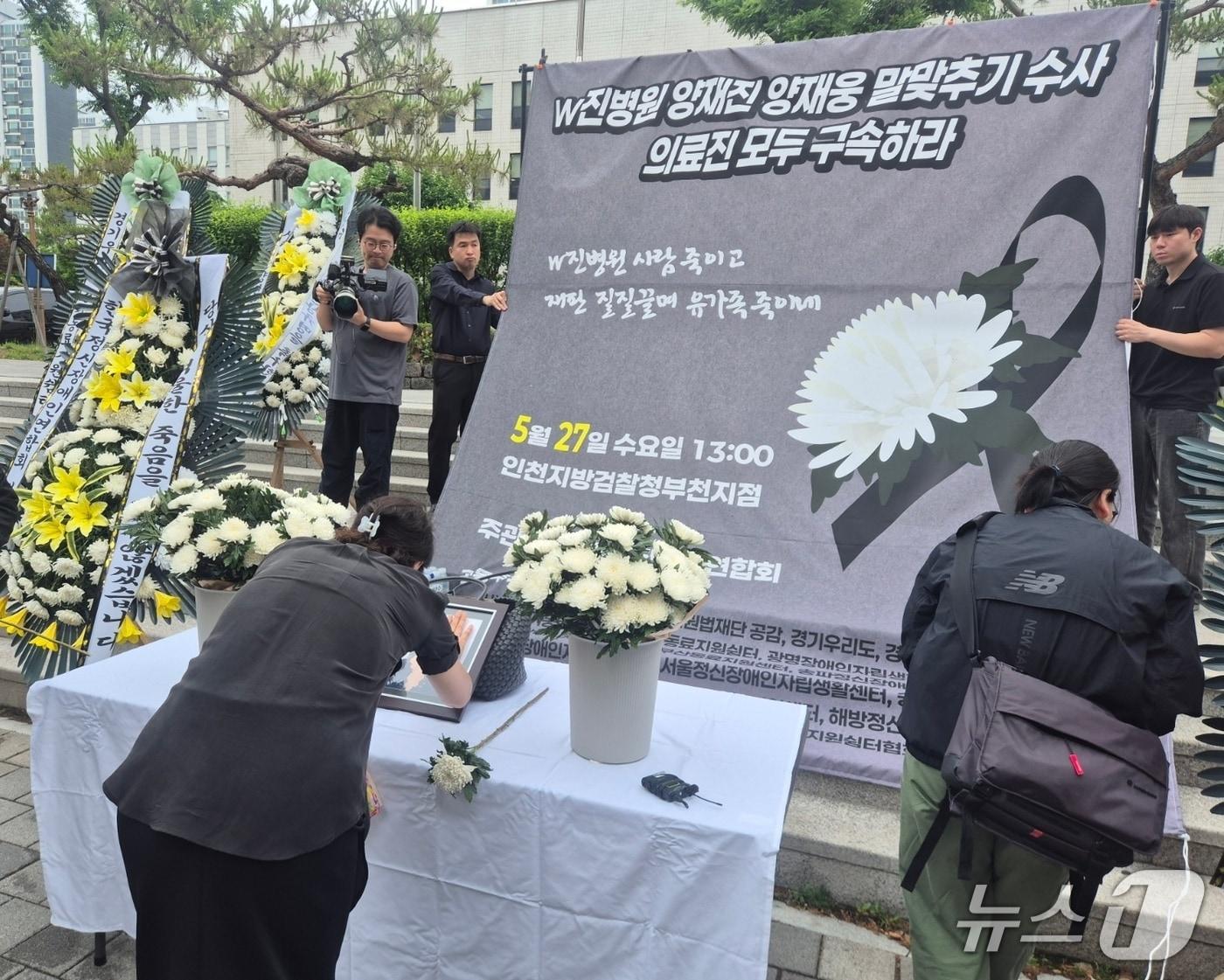 본문 이미지 - 27일 한국정신장애인연합회가 개최한 '격리·강박 사망 사건 2주기 추모제'에 참여한 유족이 헌화를 하고 있다./뉴스1
