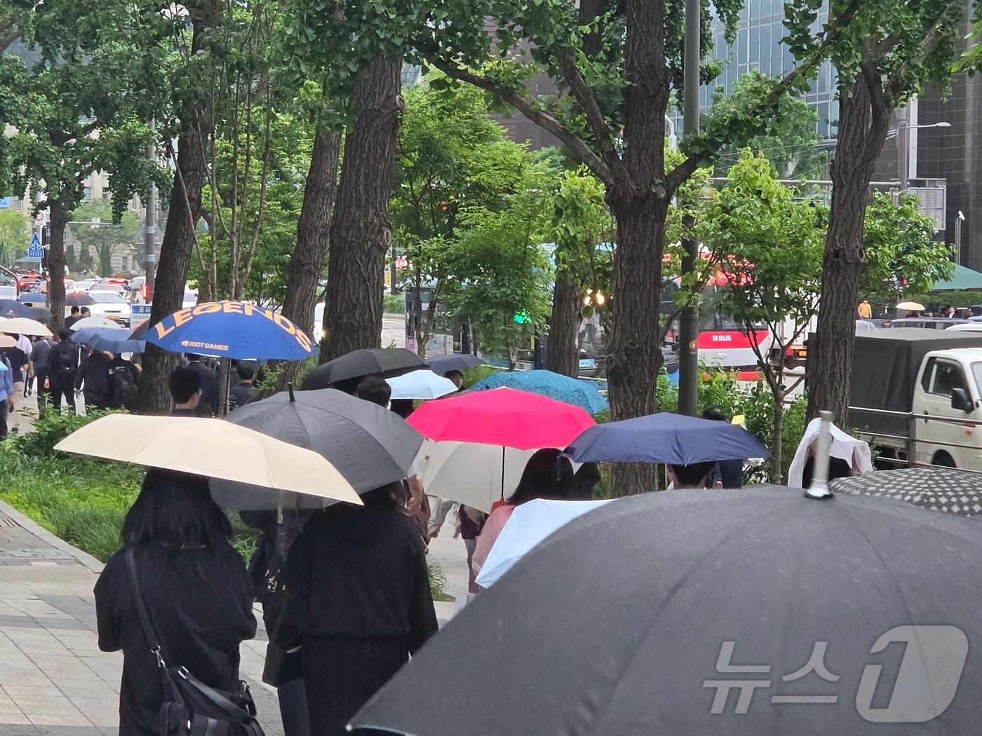 본문 이미지 - 27일 오후 서울 중구 서울시청 인근에서 시민들이 비를 피해 우산을 쓰고 있다. 2026.5.27 ⓒ 뉴스1 황덕현 기후환경전문기자