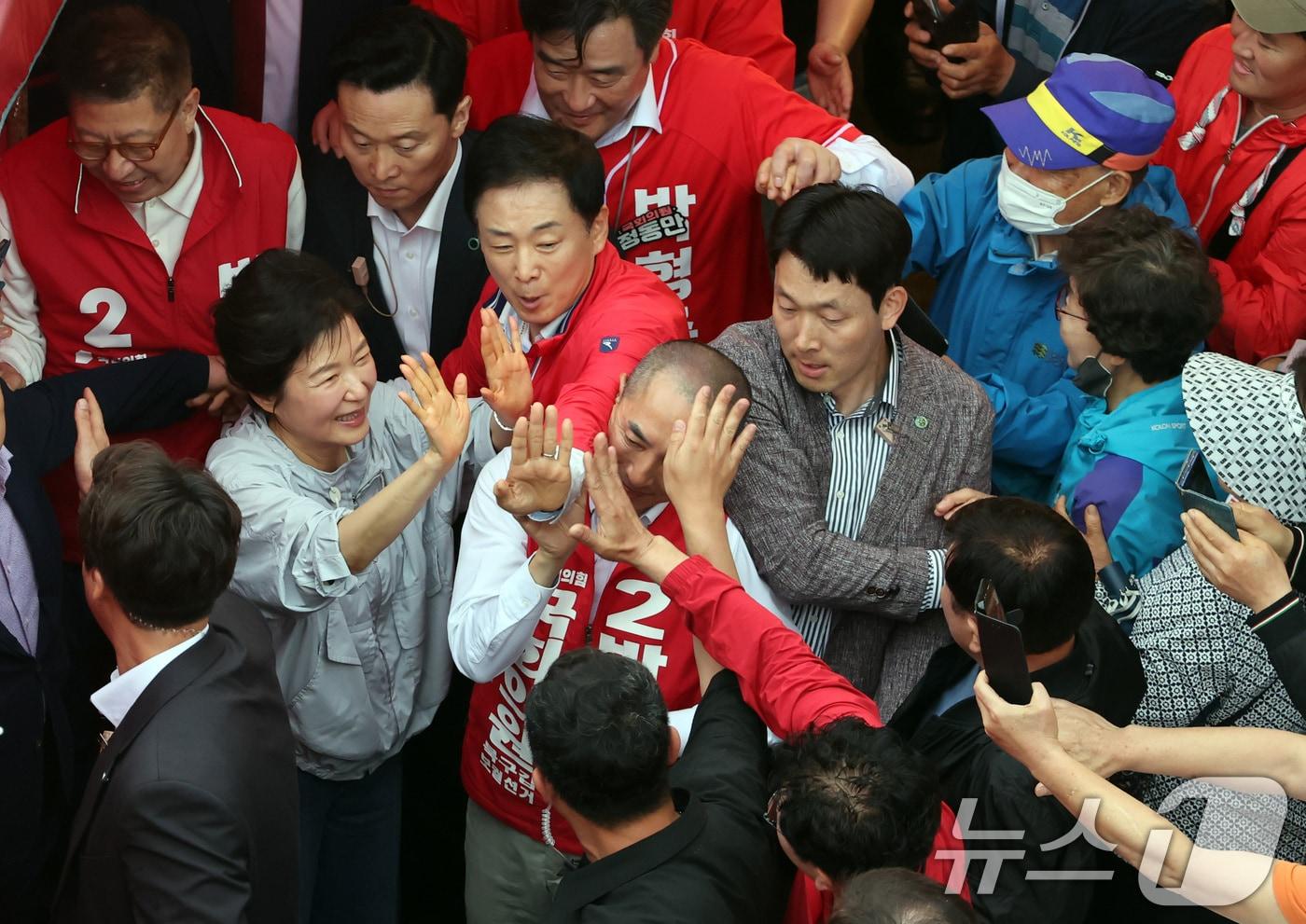 본문 이미지 - 박근혜 전 대통령이 27일 오후 부산 기장군 기장시장을 방문, 박형준 부산시장 후보 등과 함께 시민들에게 인사하며 지지를 호소하고 있다. 박 전 대통령 오른쪽은 최측근 유영하 의원. (공동취재) 2026.5.27 ⓒ 뉴스1 윤일지 기자