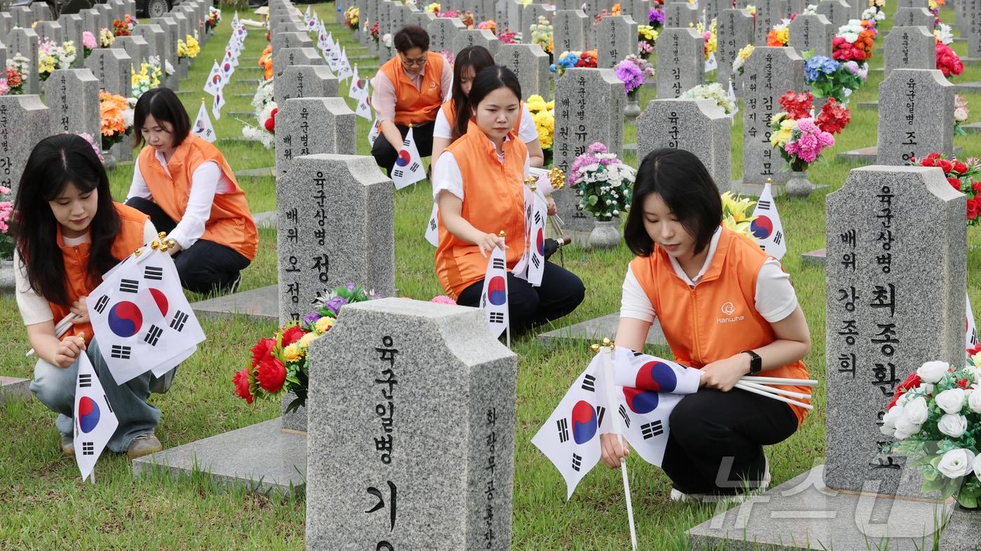 본문 이미지 - 한화그룹 충청지역 사업장 임직원 60여명으로 구성된 충청지역봉사단이 28일 대전 유성구 국립대전현충원 장병 제3묘역에서 묘역 정화활동을 진행하고 있다. 2026.5.28 ⓒ 뉴스1 김기태 기자