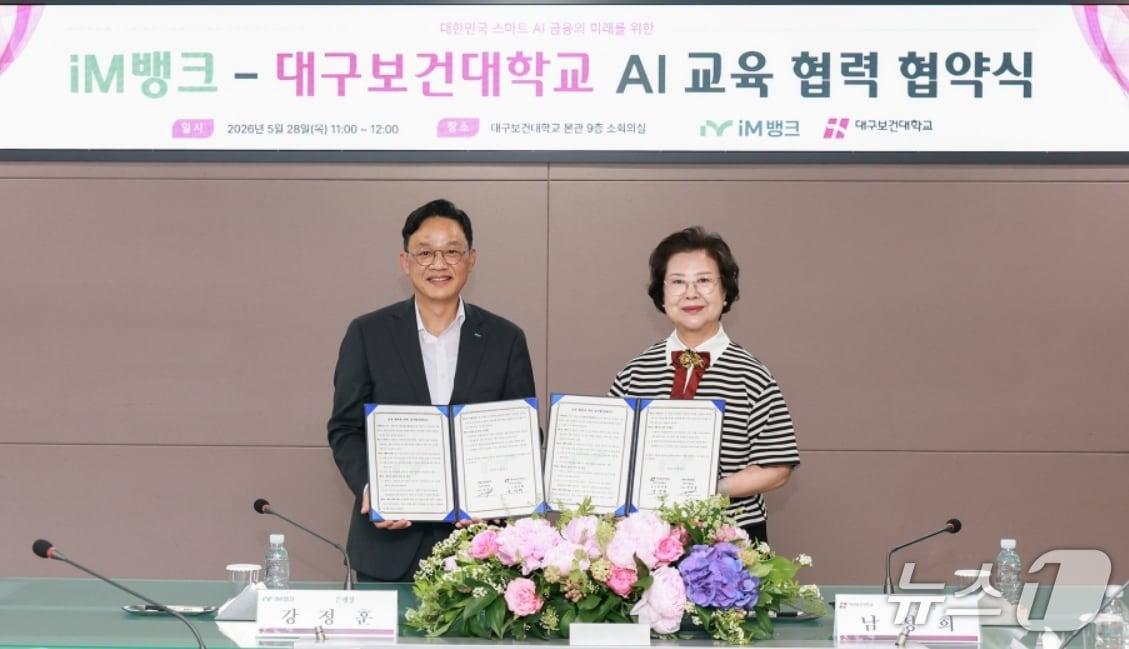 본문 이미지 - 강정훈 iM뱅크 은행장(왼쪽)과 남성희 대구보건대 총장이 임직원 인공지능(AI) 실무 역량 강화 및 미래 금융 인재 양성을 위한 교육 협력 업무협약을 체결한 뒤 협약서를 펼쳐 보이고 있다.(iM뱅크 제공, 재판매 및 DB 금지)