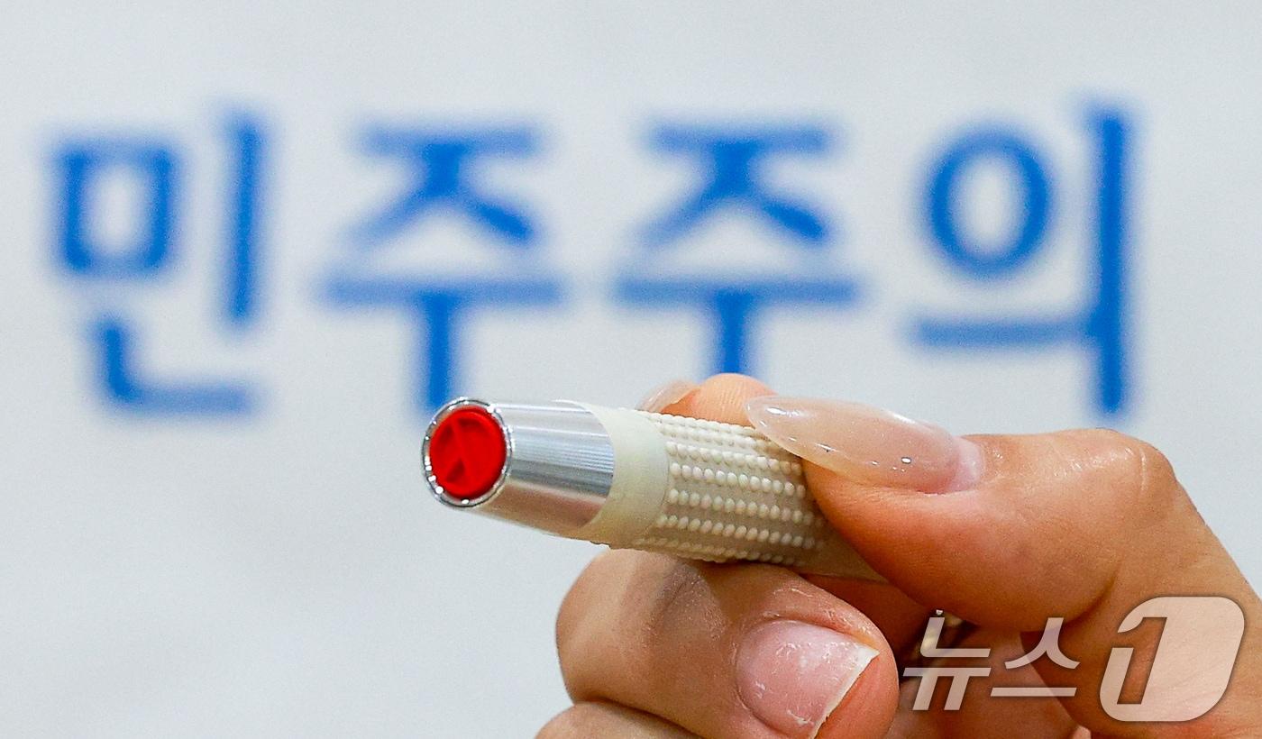 본문 이미지 - 제9회 전국동시지방선거 사전투표를 하루 앞둔 28일 오후 서울 종로구 종로1·2·3·4가동주민센터에 마련된 사전투표소에서 관계자가 기표용구를 들어보이고 있다. 2026.5.28 ⓒ 뉴스1 안은나 기자