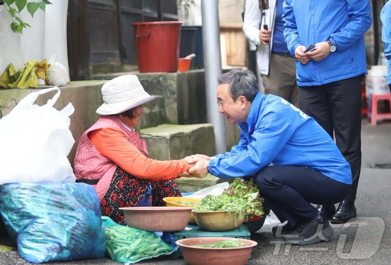 본문 이미지 - 임문영 더불어민주당 광주 광산을 재보선 후보가 유세 도중 전통시장에서 채소를 파는 노점상과 악수하고 있다.(임문영 캠프 제공. 재배포 및 DB 금지)
