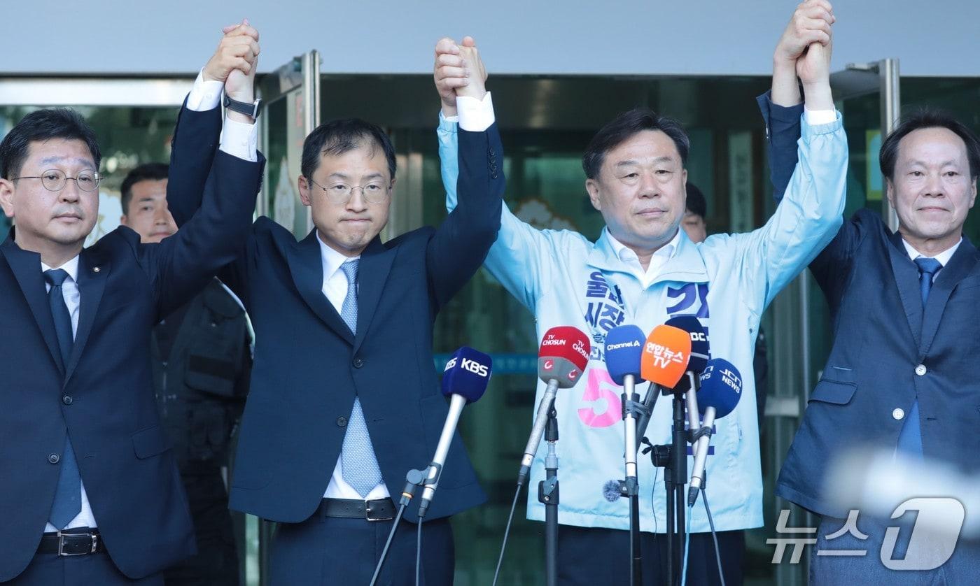 본문 이미지 - 왼쪽부터 김태선 민주당 울산시당위원장, 김상욱 민주당 울산시장 후보, 김종훈 진보당 울산시장 후보, 방석수 진보당 울산시당위원장이 28일 울산선거관리위원회에서 진보진영 단일화에 대한 기자회견을 끝내고 손을 맞잡아 들었다. 2026.5.28/뉴스1 박정현 기자
