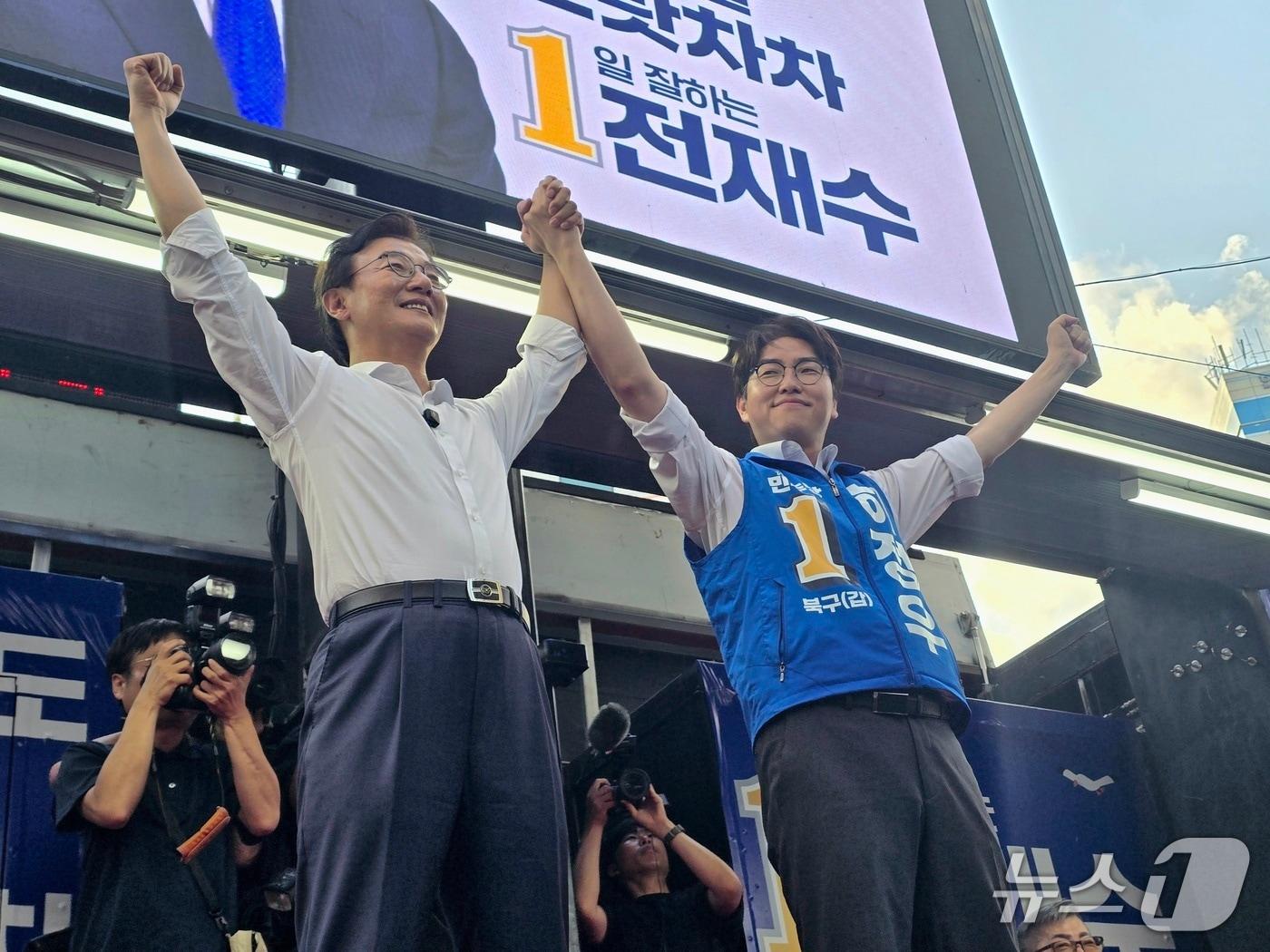 본문 이미지 - 전재수 후보와 하정우 후보가 28일 부산 북구 덕천동 젊음의거리에서 열린 합동 유세에서 손을 잡아 들어 올리며 시민들에게 인사하고 있다.2026.5.28 ⓒ 뉴스1 이주현 기자