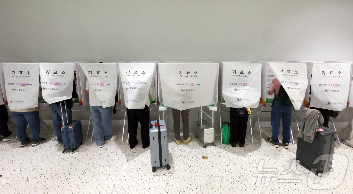 본문 이미지 - 6·3지방선거 사전투표가 시작된 29일 오전 인천국제공항 제1터미널 출국장에 설치된 사전투표소에서 시민들이 출국 전 사전투표를 하고 있다. 2026.5.29 ⓒ 뉴스1 김진환 기자