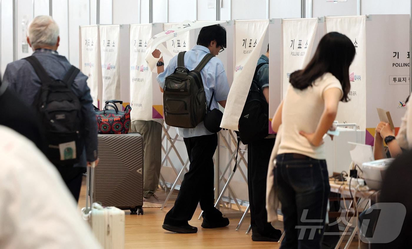 본문 이미지 - 6·3지방선거 사전투표가 시작된 29일 오전 인천국제공항 제2터미널 출국장에 설치된 사전투표소에서 시민들이 출국 전 사전투표를 하고 있다. 2026.5.29 ⓒ 뉴스1 김진환 기자