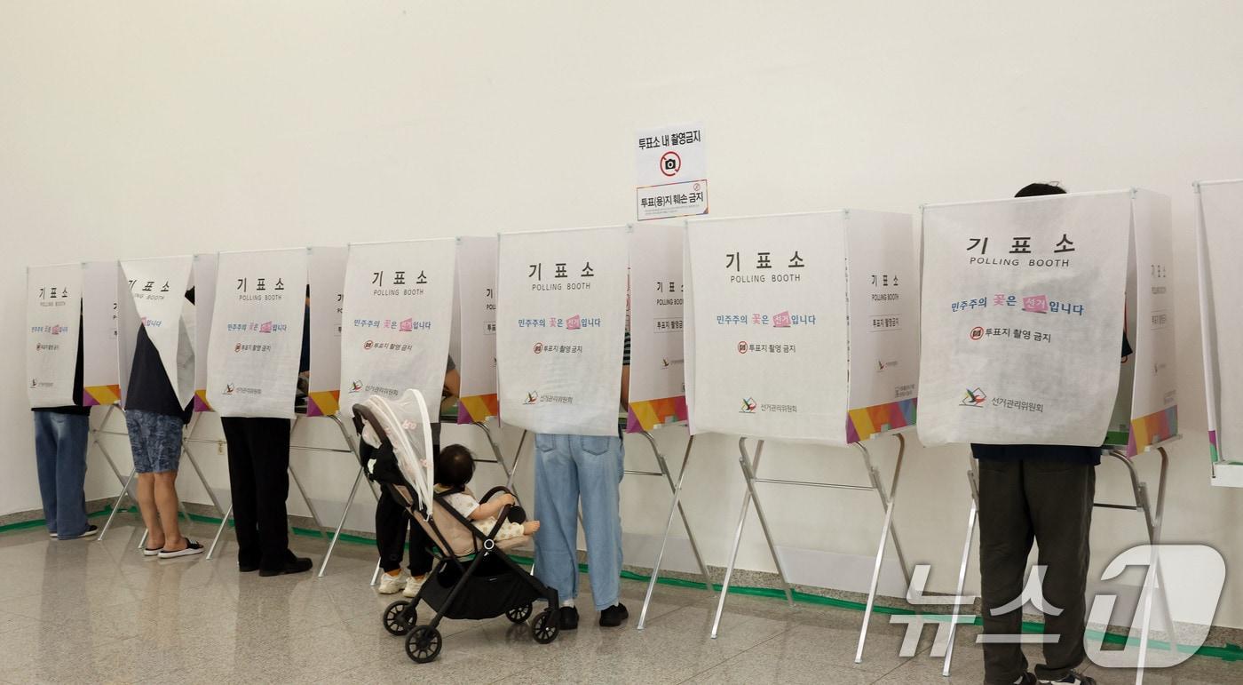 본문 이미지 - 전국동시지방선거 사전투표 첫날인 29일 광주 북구 용봉동 사전투표소로 지정된 전남대학교 용지관컨벤션홀에서 유아차에 아이를 데리고 온 유권자가 투표를 하고 있다. 2026.5.29 ⓒ 뉴스1 박지현 기자