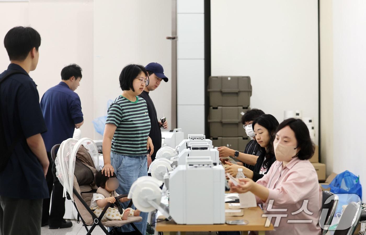본문 이미지 - 전국동시지방선거 사전투표 첫날인 29일 광주 북구 용봉동 사전투표소로 지정된 전남대학교 용지관컨벤션홀에서 유아차에 아이를 데리고 온 시민이 투표하고 있다. ⓒ 뉴스1 박지현 기자