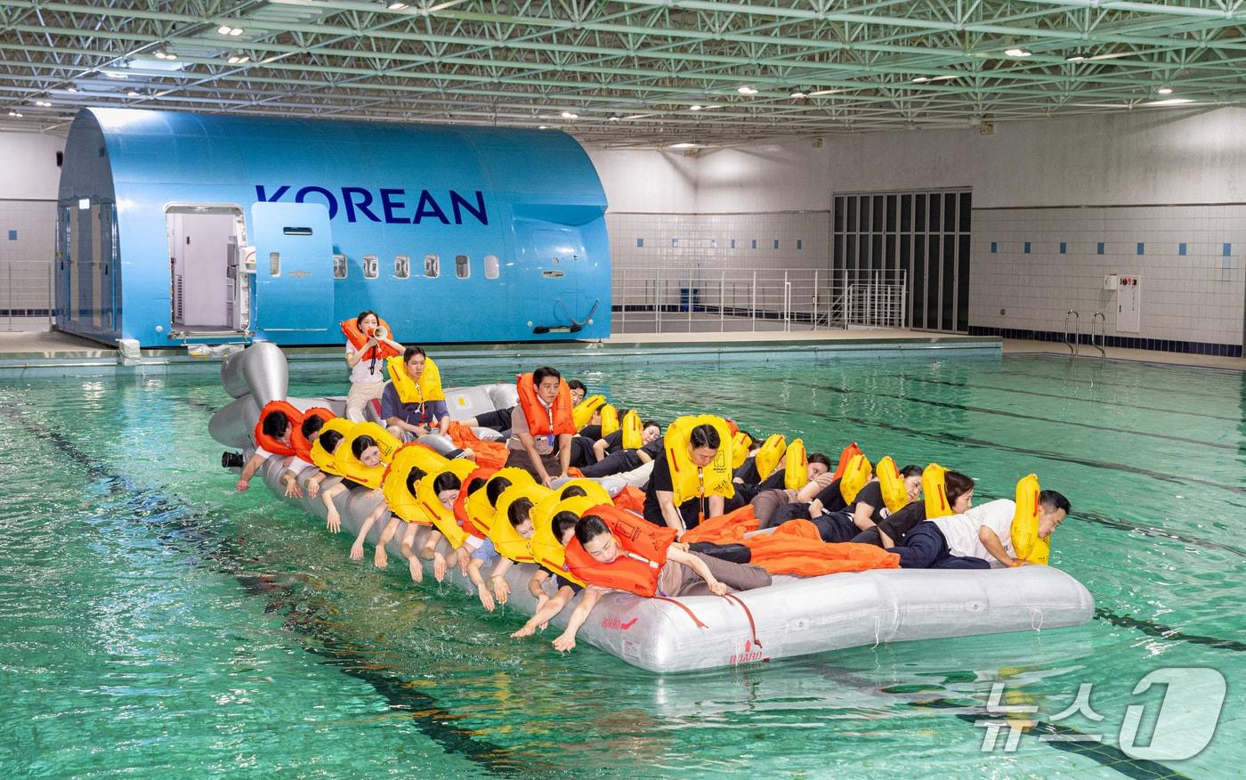 본문 이미지 - 대한항공과 아시아나항공의 통합 비상탈출시범 중 객실승무원들이 대한항공 객실훈련센터에서 구명정 탑승 시범을 진행하는 모습(대한항공 제공)