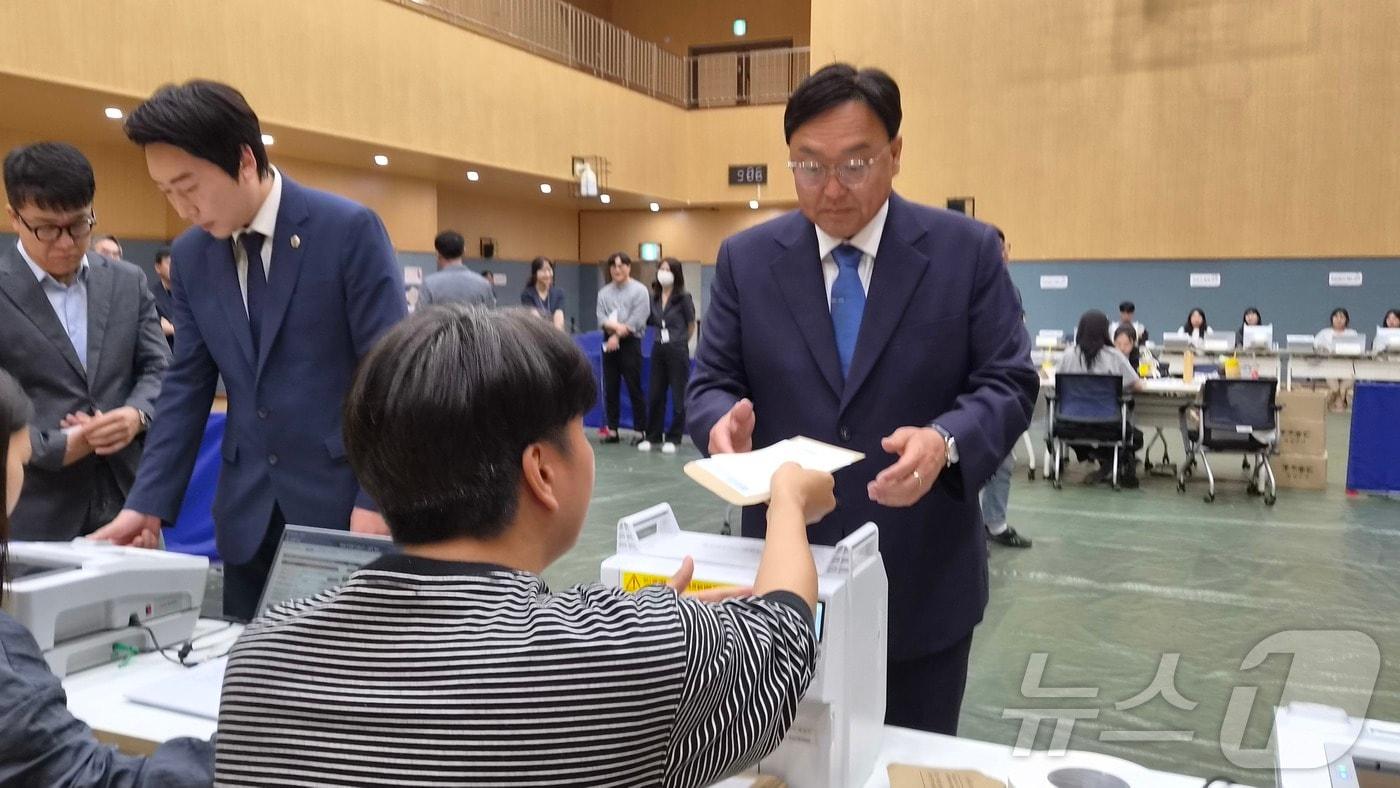 본문 이미지 - 9회 전국동시지방선거 사전투표 첫날인 29일 세종시 나성동 행정복지센터에 마련된 사전투표소에서 더불어민주당 조상호 세종시장 후보가 선대위 관계자들과 투표용지를 받고 있다. 2026.5.29 ⓒ 뉴스1 장동열 기자