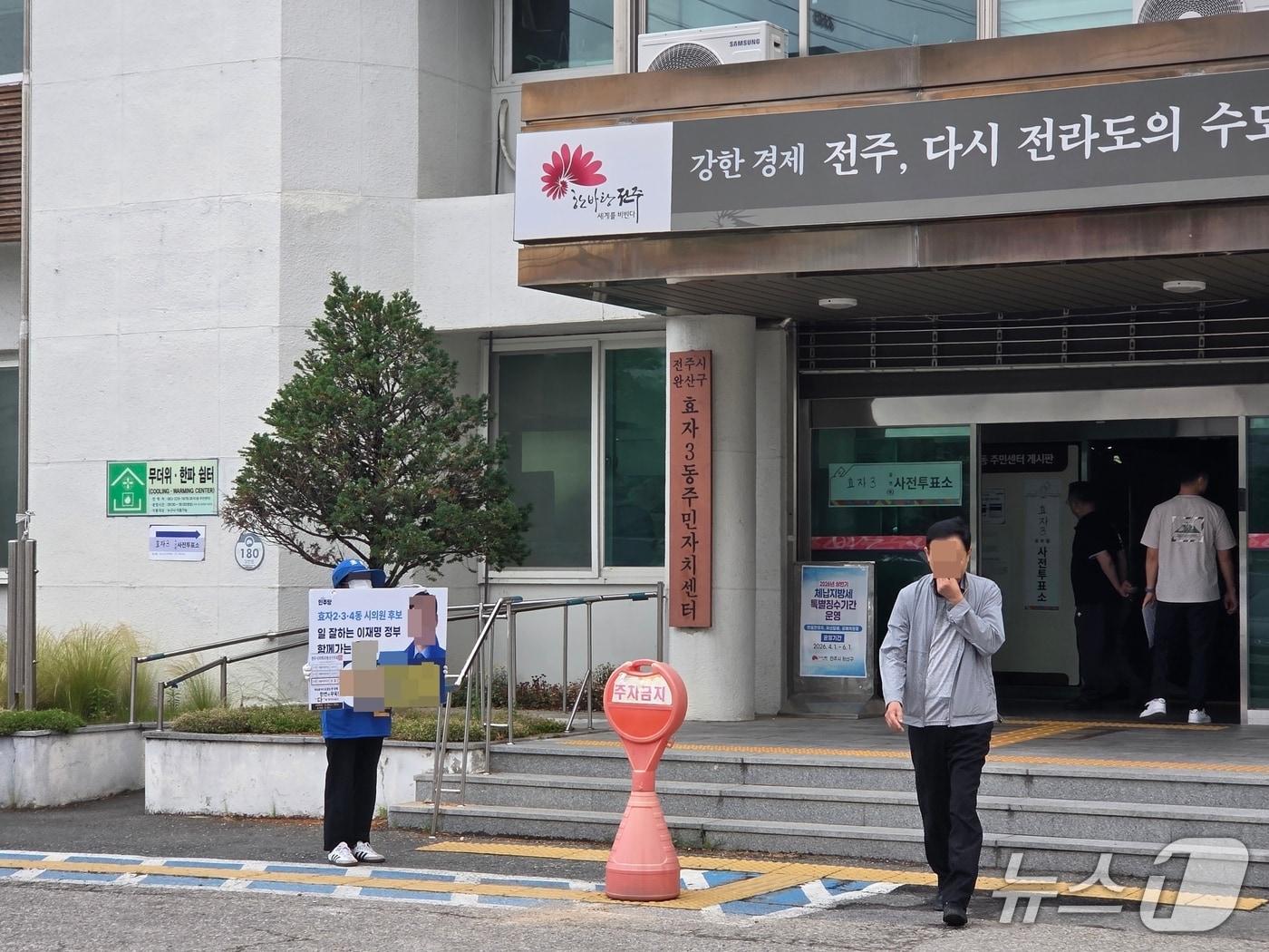 본문 이미지 - 29일 오전 전북 전주시 완산구 효자3동 사전투표소 앞에서 한 선거운동원이 피켓을 들고 선거운동을 하고 있다. 공직선거법에 따라 투표소 반경 100미터안에서는 특정 정당이나 후보자를 지지하거나 반대하는 언동을 할 수 없다./뉴스1 장수인 기자