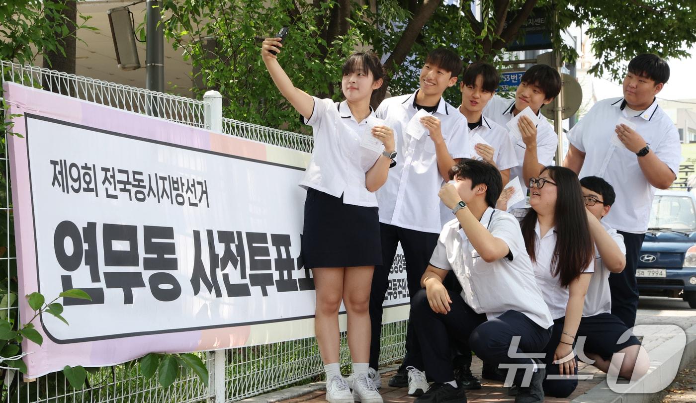 본문 이미지 - 6·3지방선거와 국회의원 재·보궐선거 사전투표 첫날인 29일 경기 수원시 장안구 연무동 행정복지센터에 마련된 사전투표소에서 사전투표를 마친 삼일공업고등학교 3학년 학생들이 투표확인증을 들고 인증샷을 남기고 있다. ⓒ 뉴스1 김영운 기자